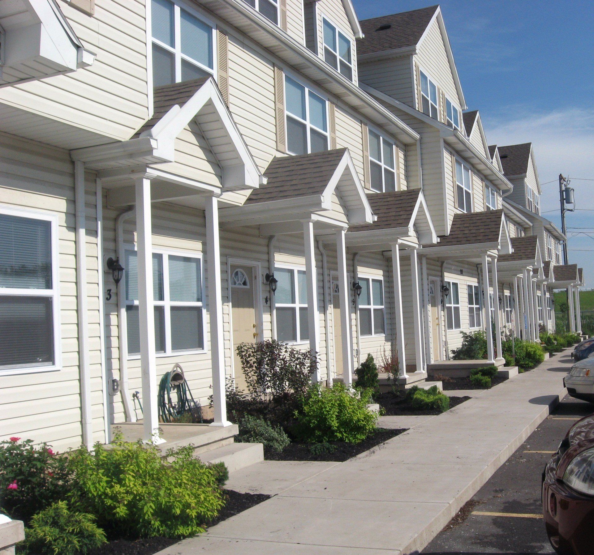 A row of houses with a sidewalk in front of them