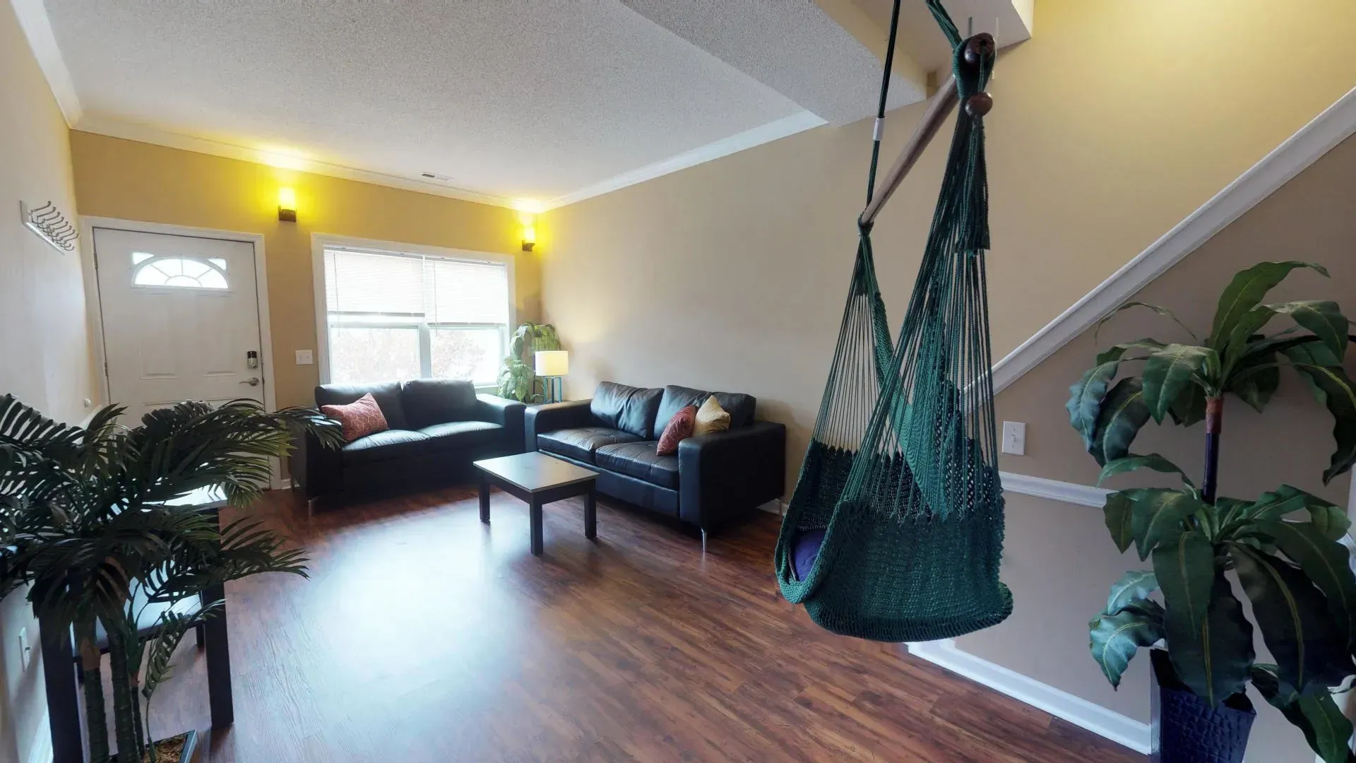 A living room with a hammock hanging from the ceiling