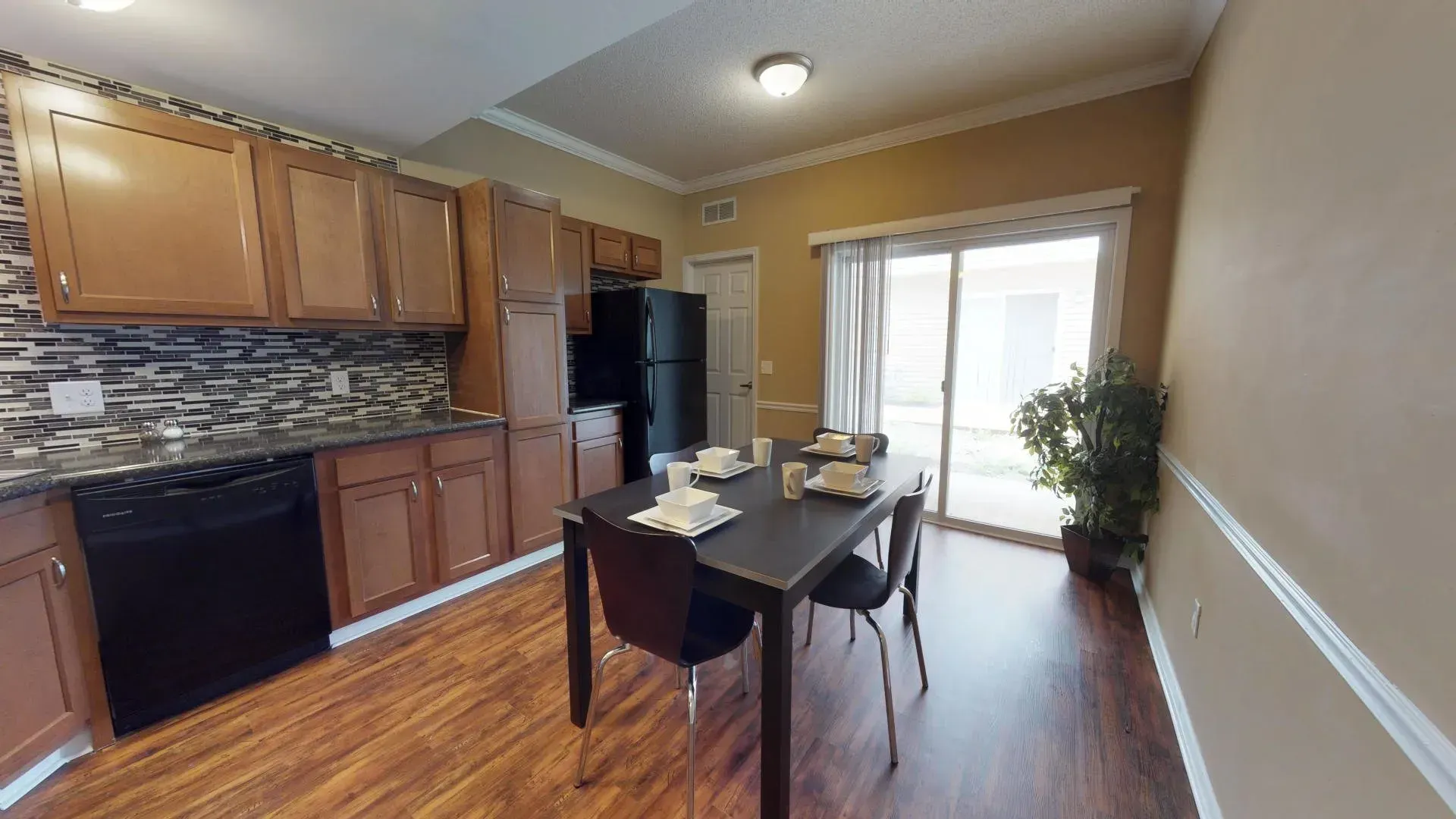 A kitchen and dining room in a house with a table and chairs.