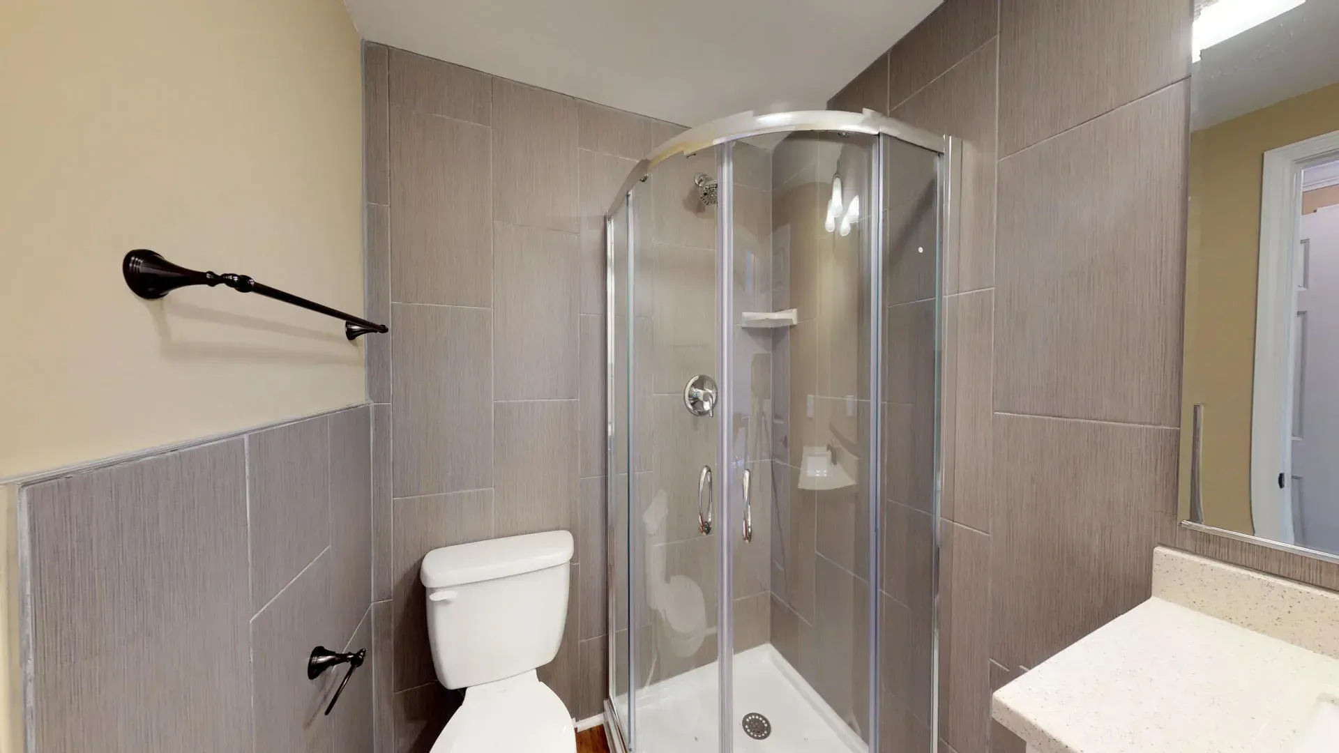 A bathroom with a toilet , sink and shower stall.