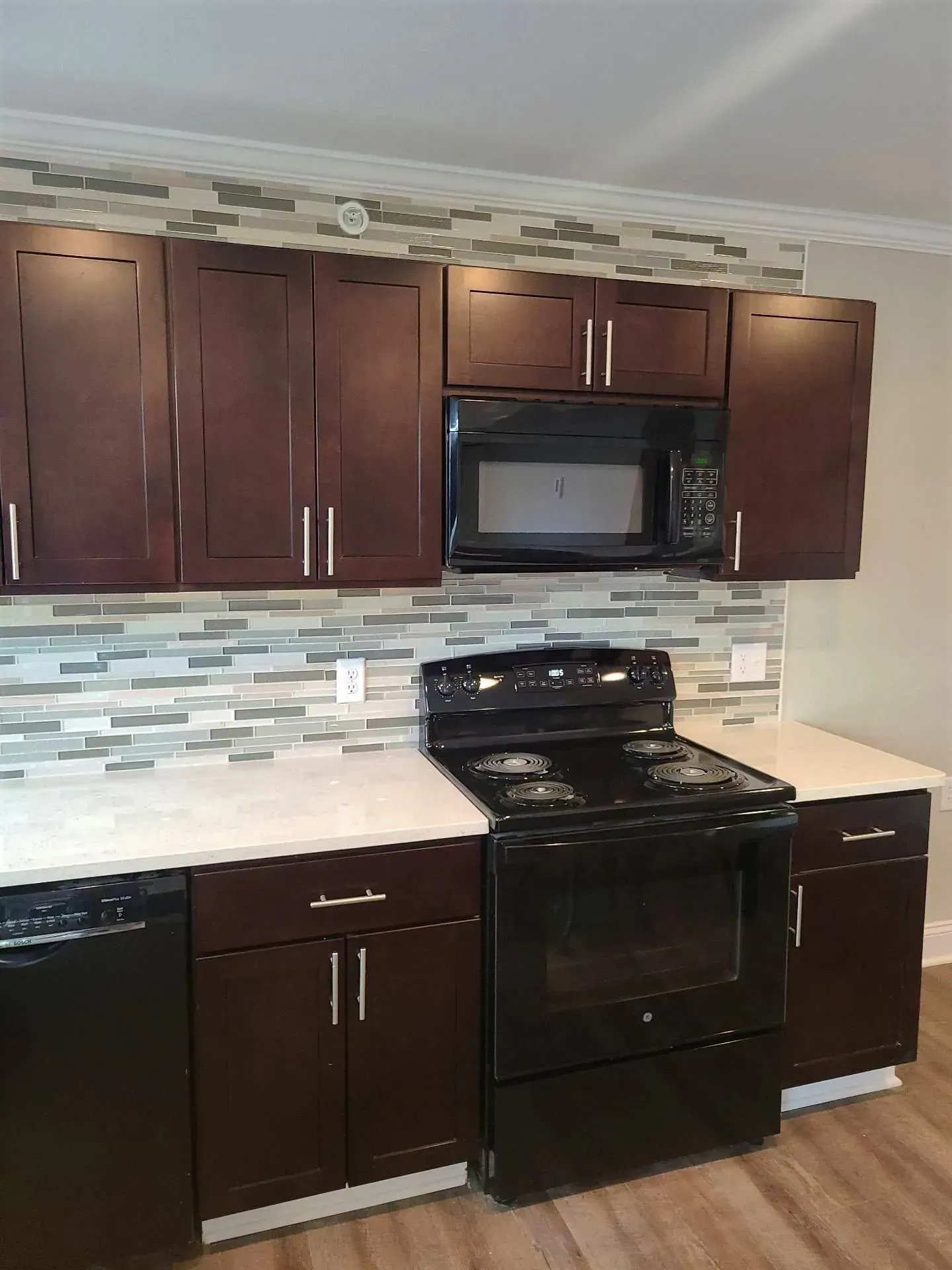 A kitchen with a stove , dishwasher , and microwave.