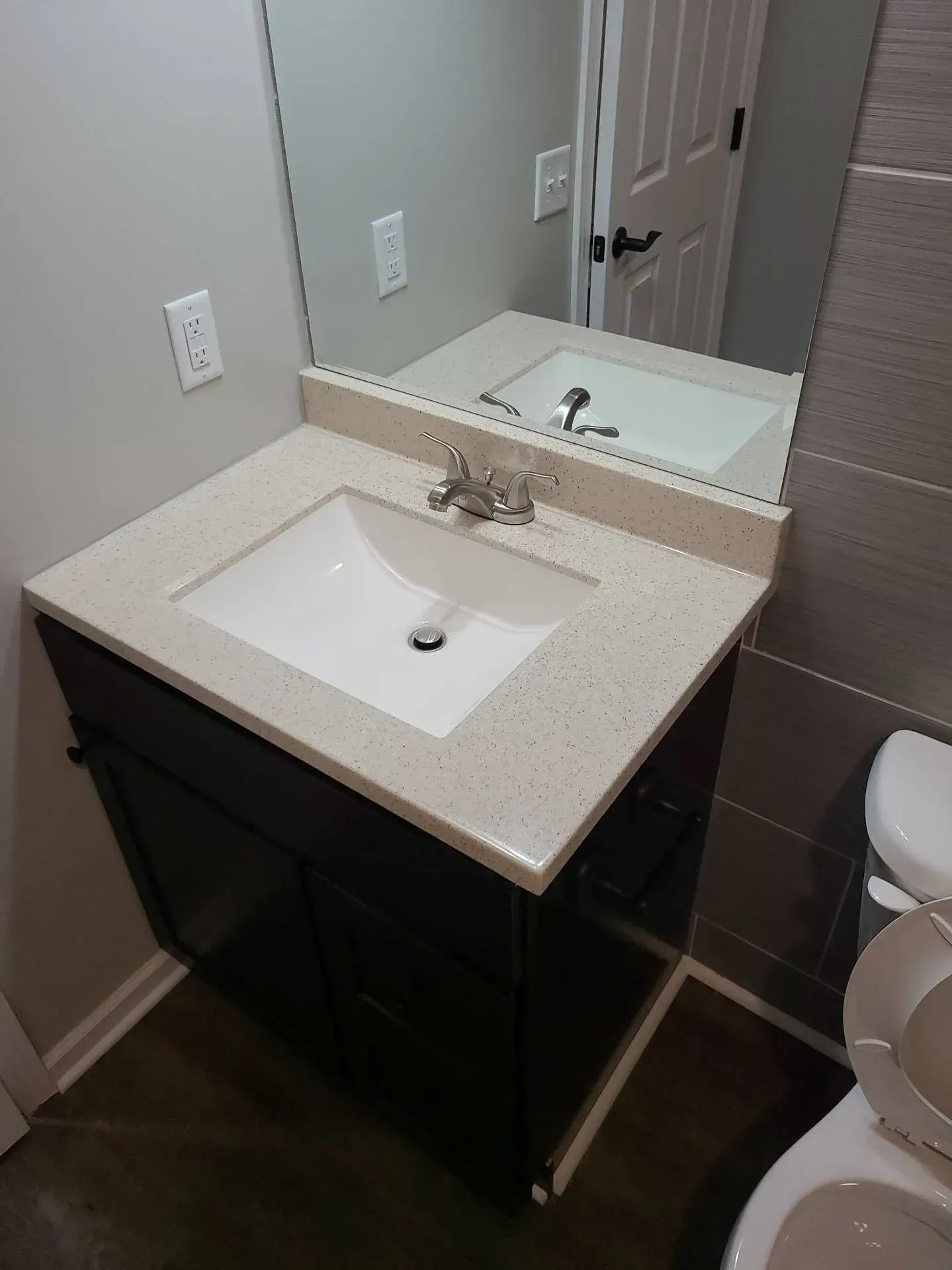 A bathroom with a sink , toilet and mirror.