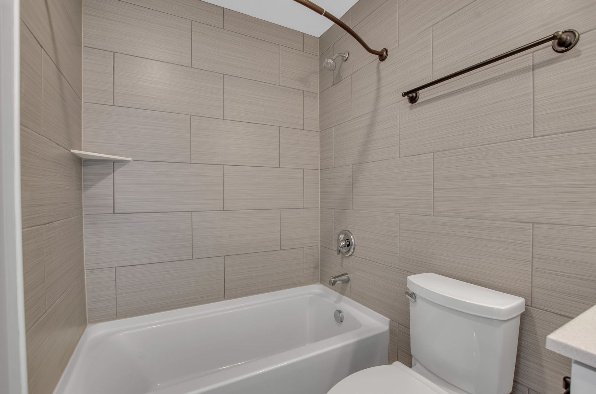 A bathroom with a tub , toilet and shower.