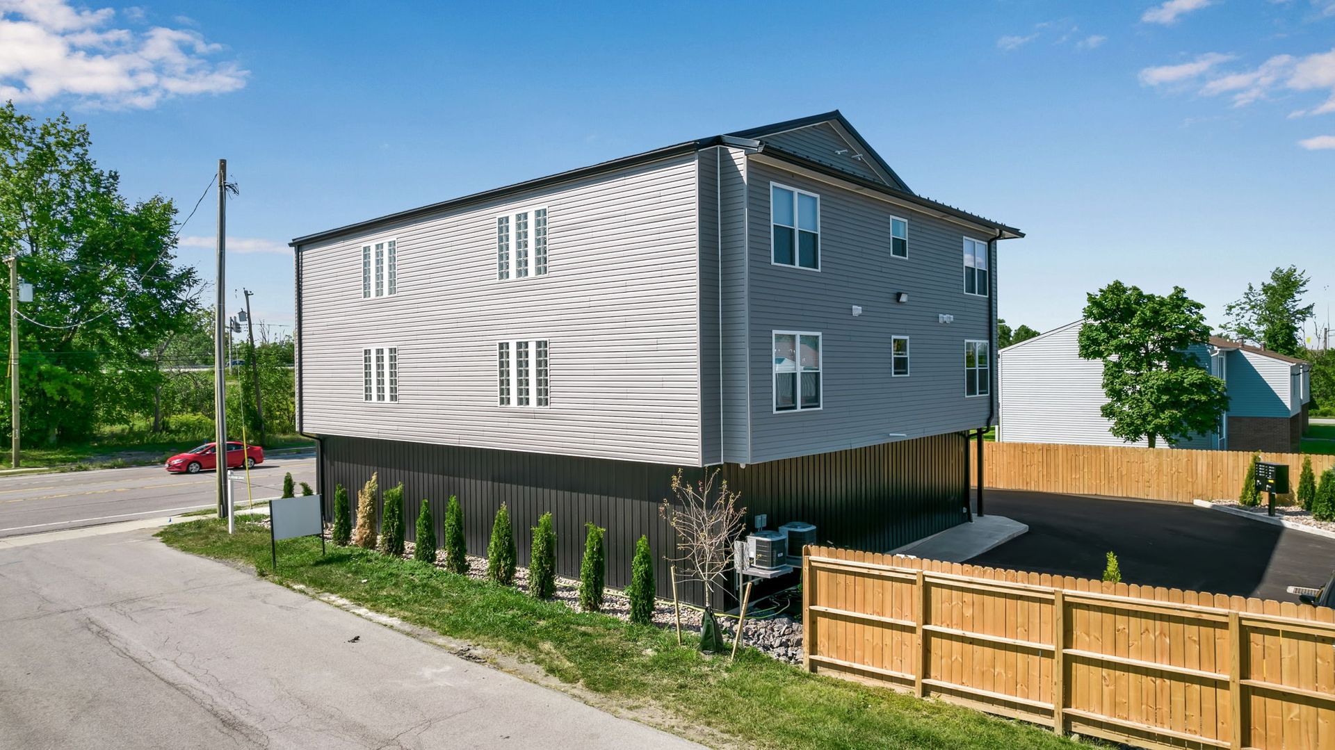 A large white house with a wooden fence in front of it.