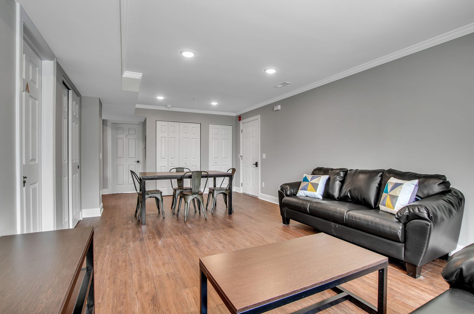 A living room with a couch , table and chairs.