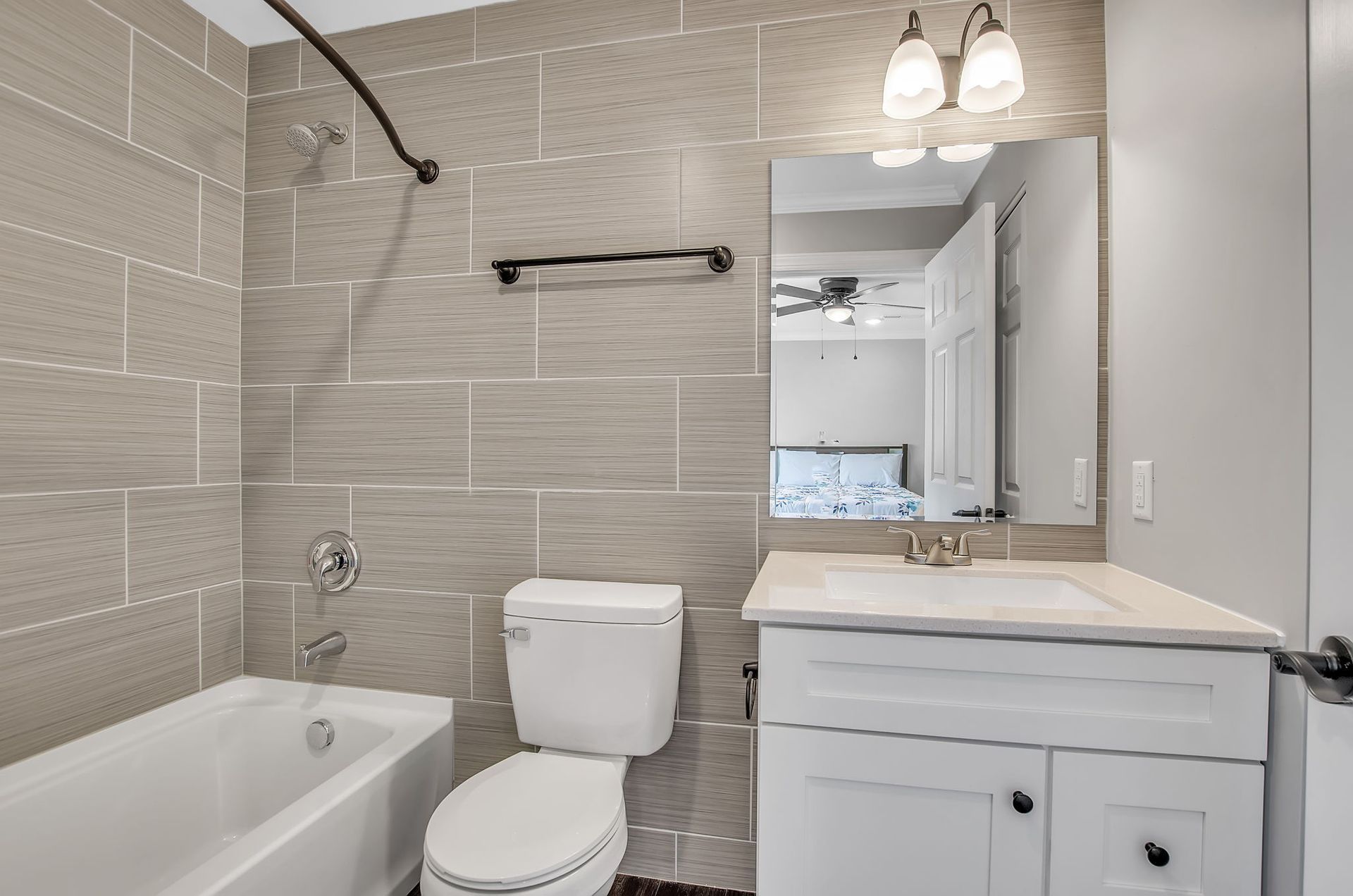 A bathroom with a toilet , sink , bathtub and mirror.