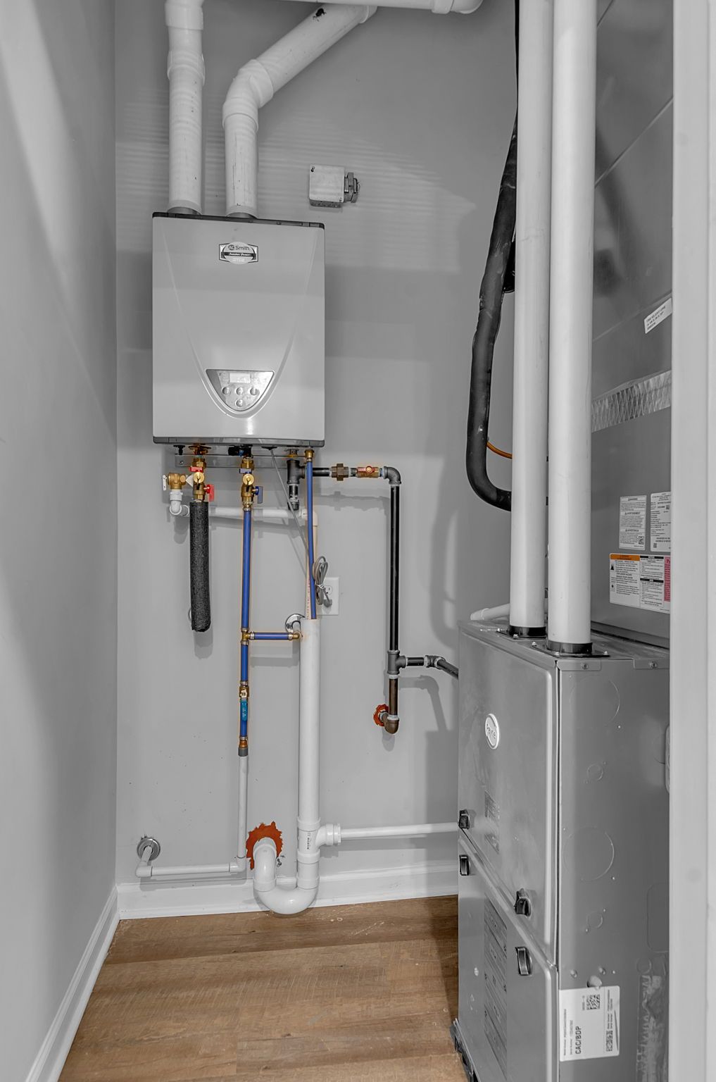 A room with a boiler and a water heater in it.