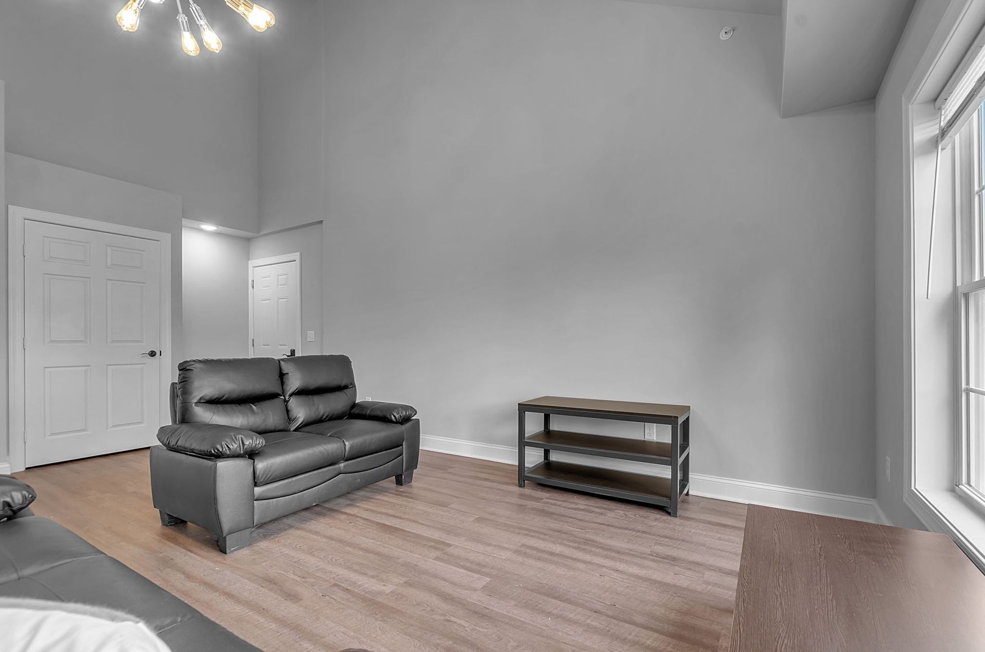 An empty living room with a couch and a window.