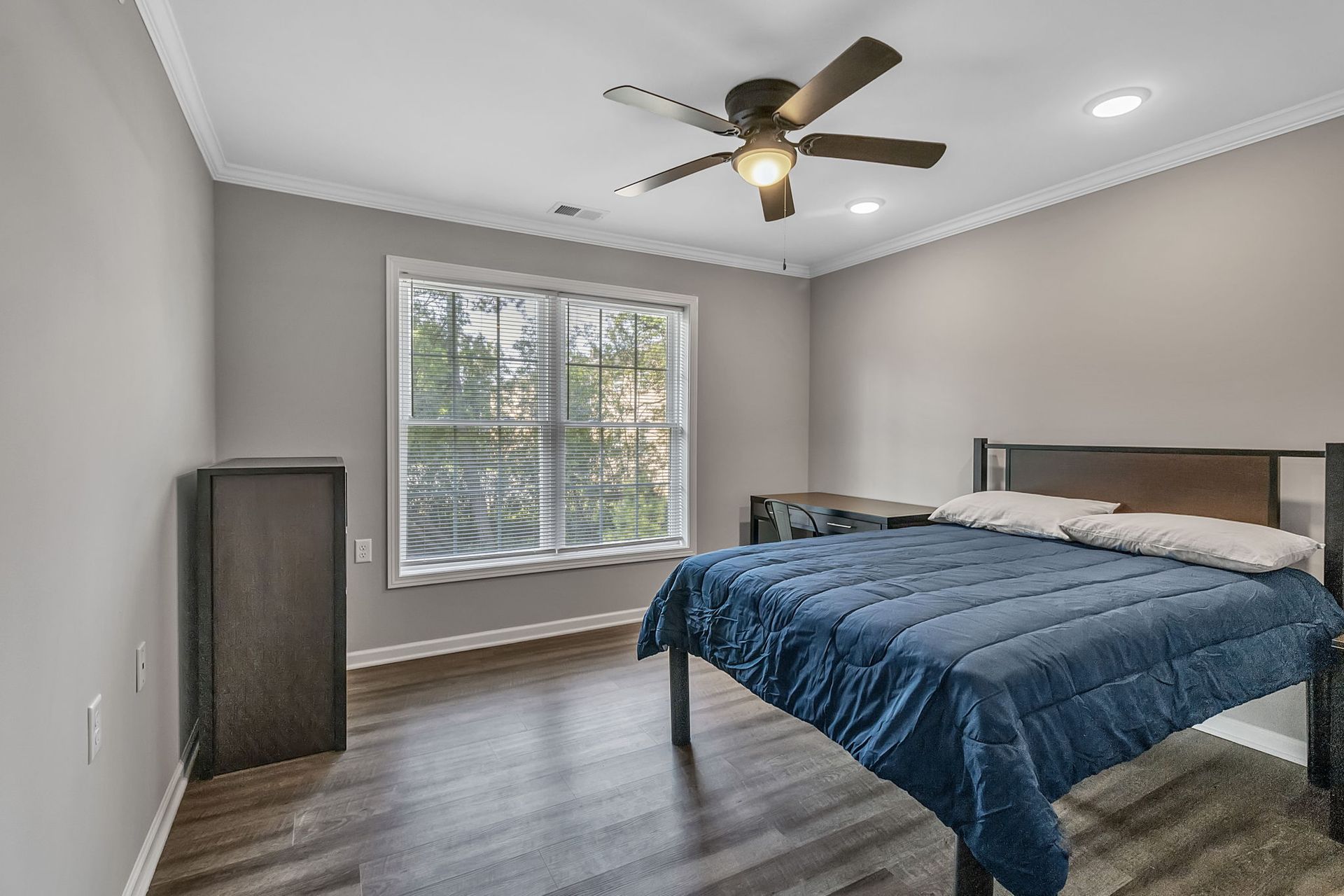 A bedroom with a bed and a ceiling fan.