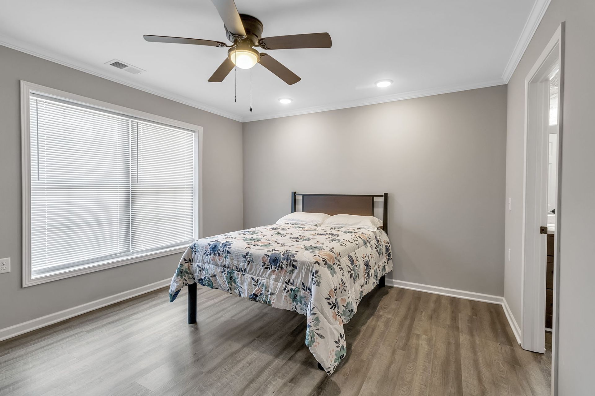 A bedroom with a bed and a ceiling fan