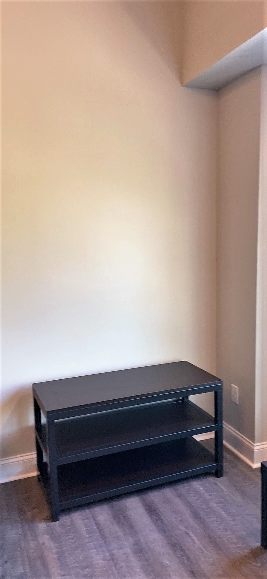 There is a shelf in the corner of the room.