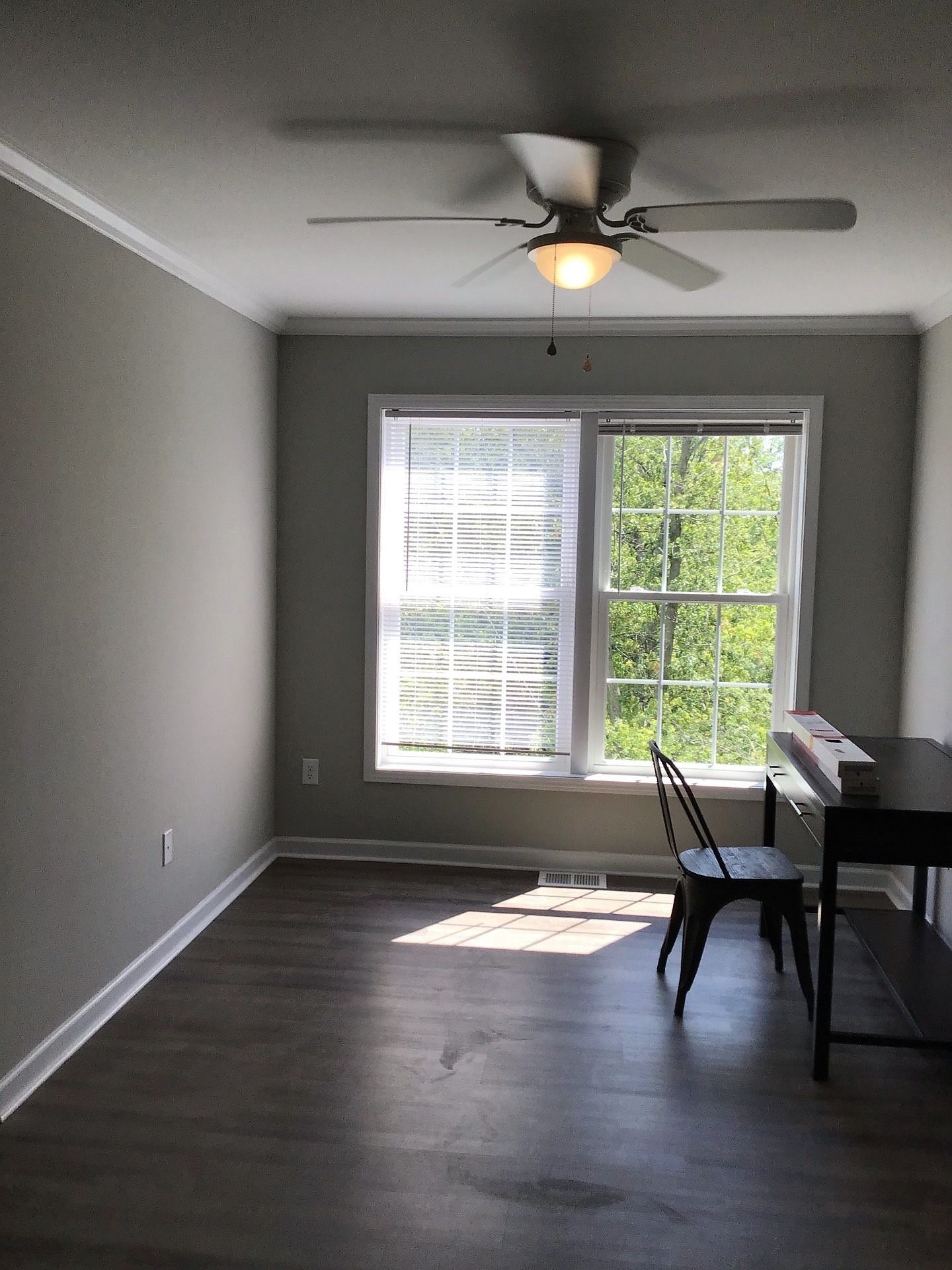 A living room with a ceiling fan and a piano.