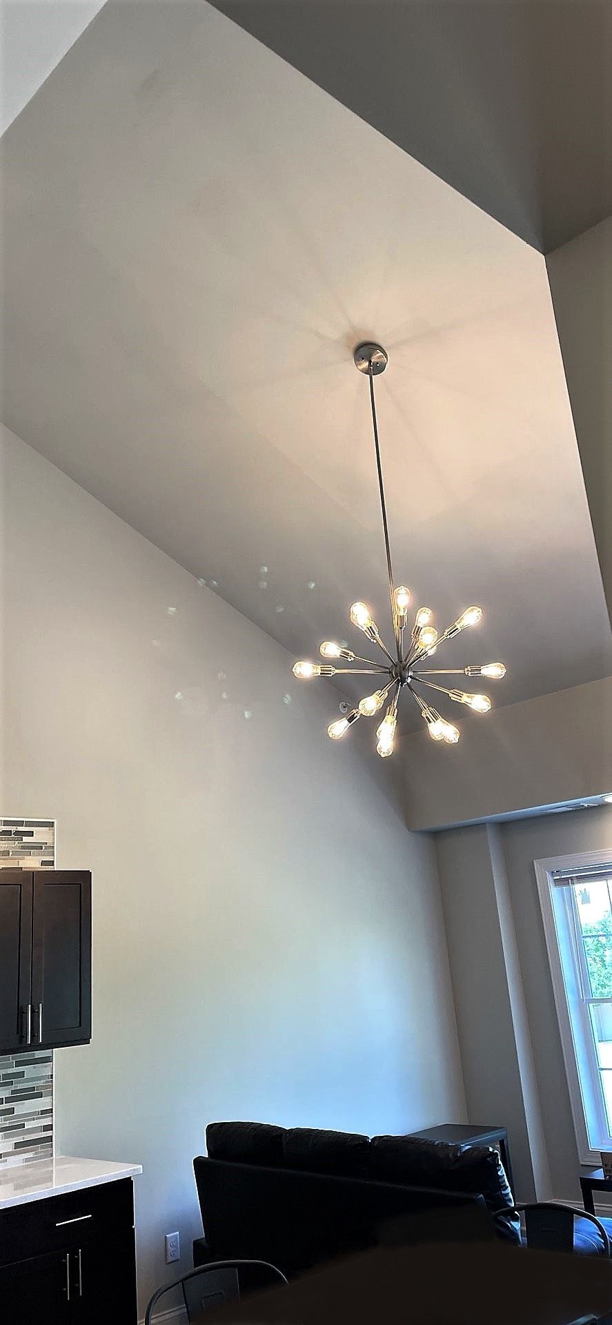 A living room with a chandelier hanging from the ceiling.