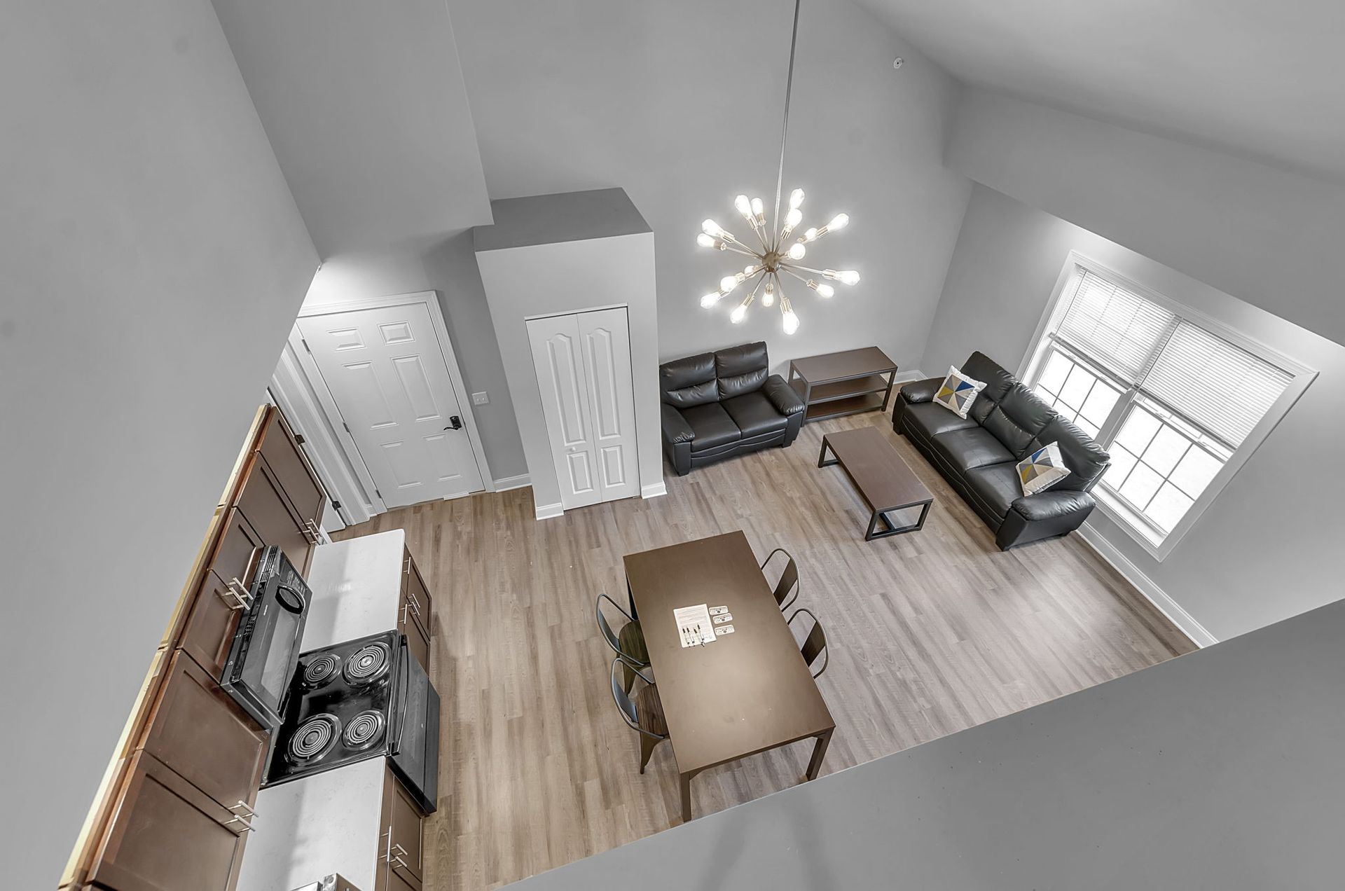 An aerial view of a living room with a couch , table and chairs.