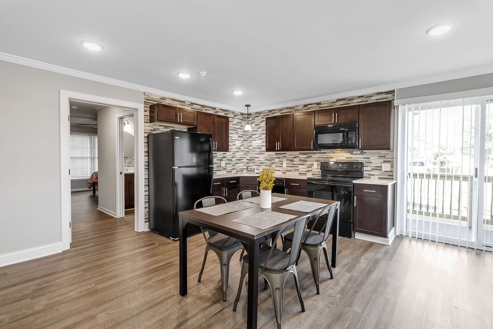 A kitchen and dining room in a house with a table and chairs.