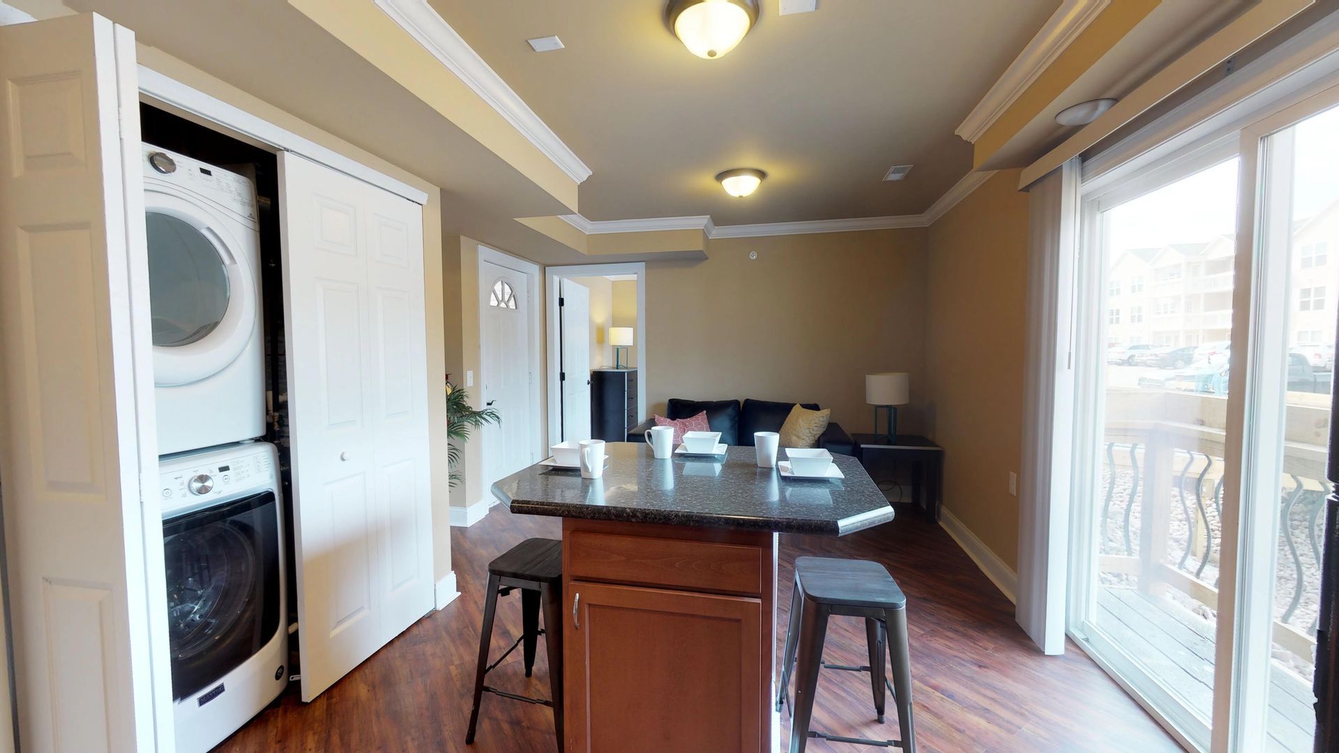 A kitchen with a washer and dryer stacked on top of each other.