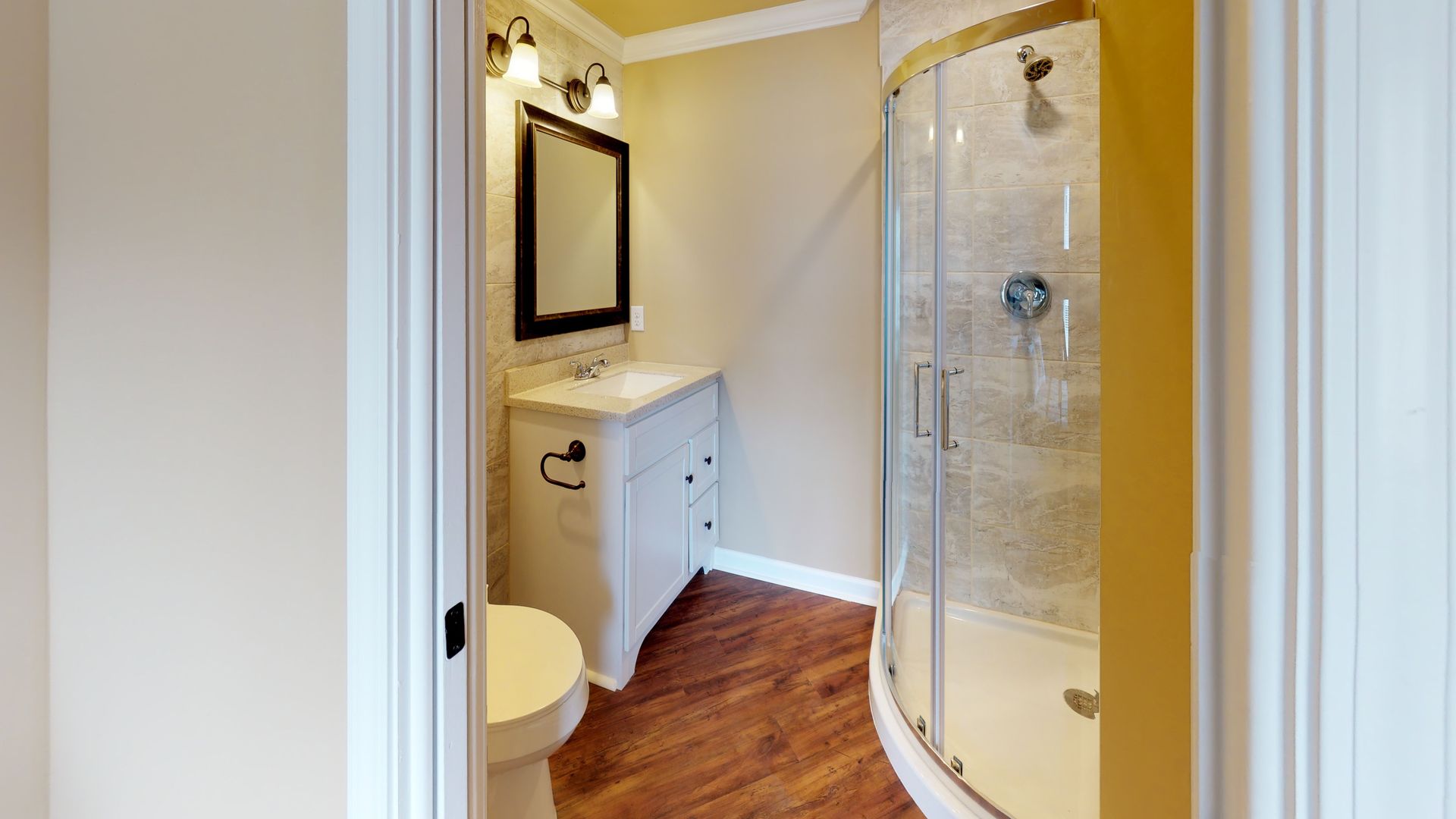 A bathroom with a toilet , sink and shower.