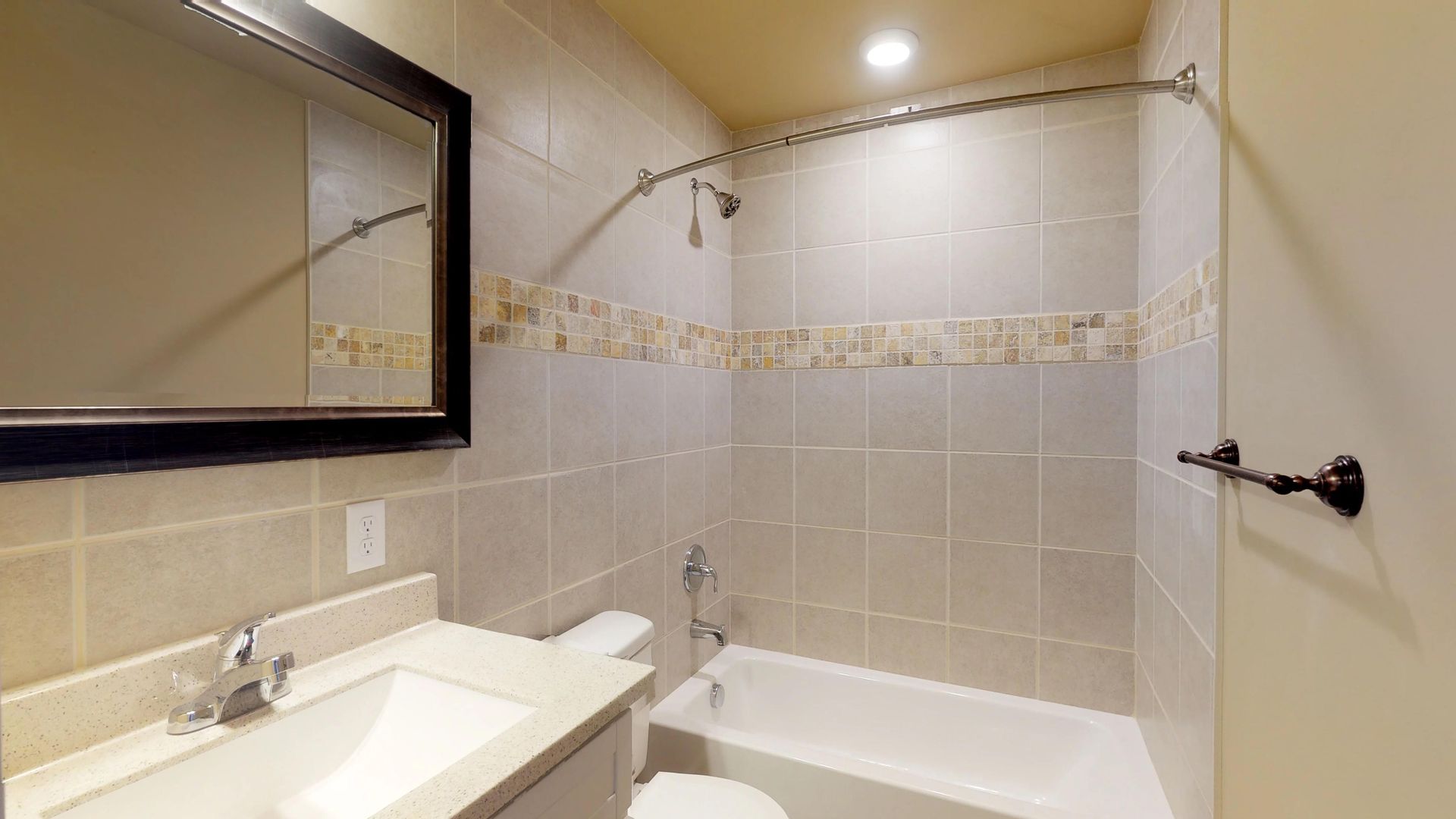 A bathroom with a sink , toilet , tub and mirror.