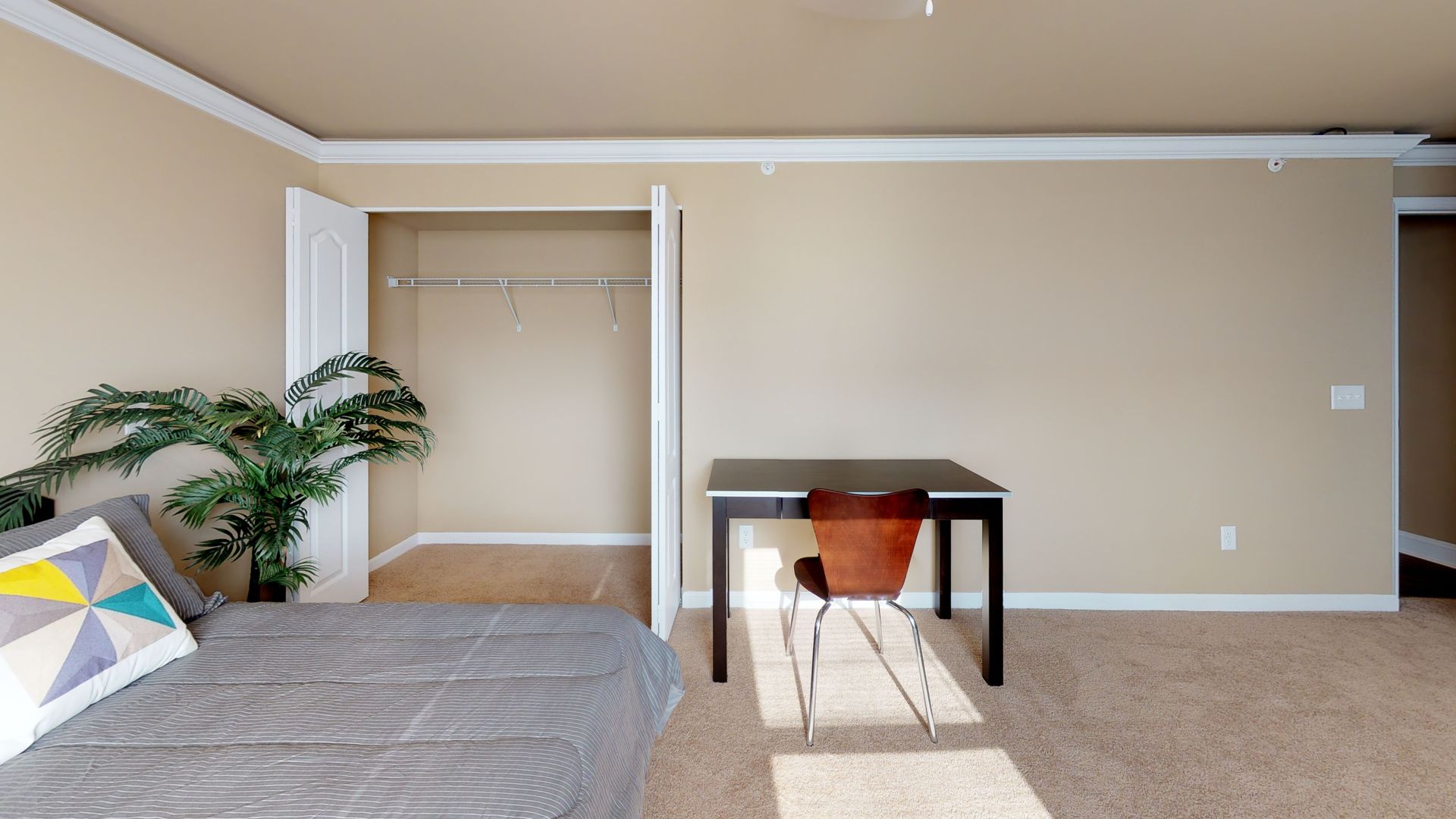 A bedroom with a bed , desk , chair and closet.