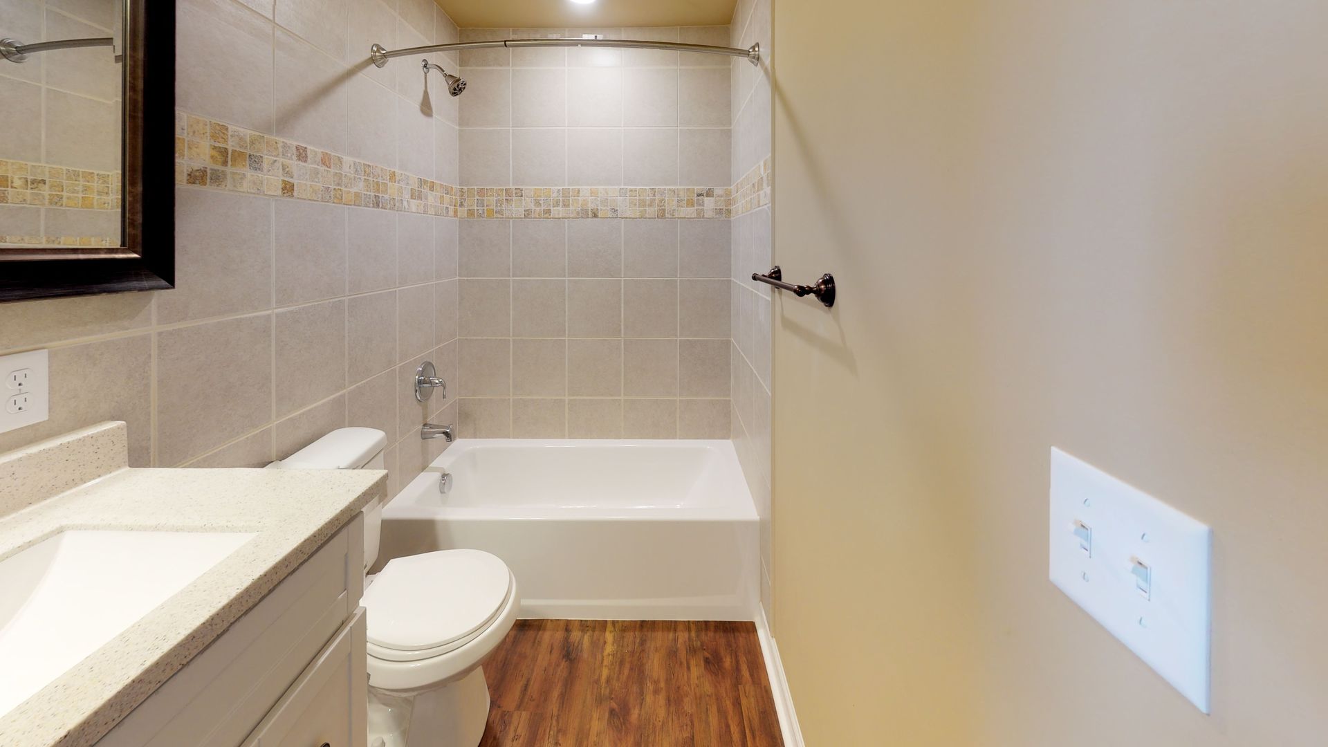 A bathroom with a toilet , sink , bathtub and mirror.