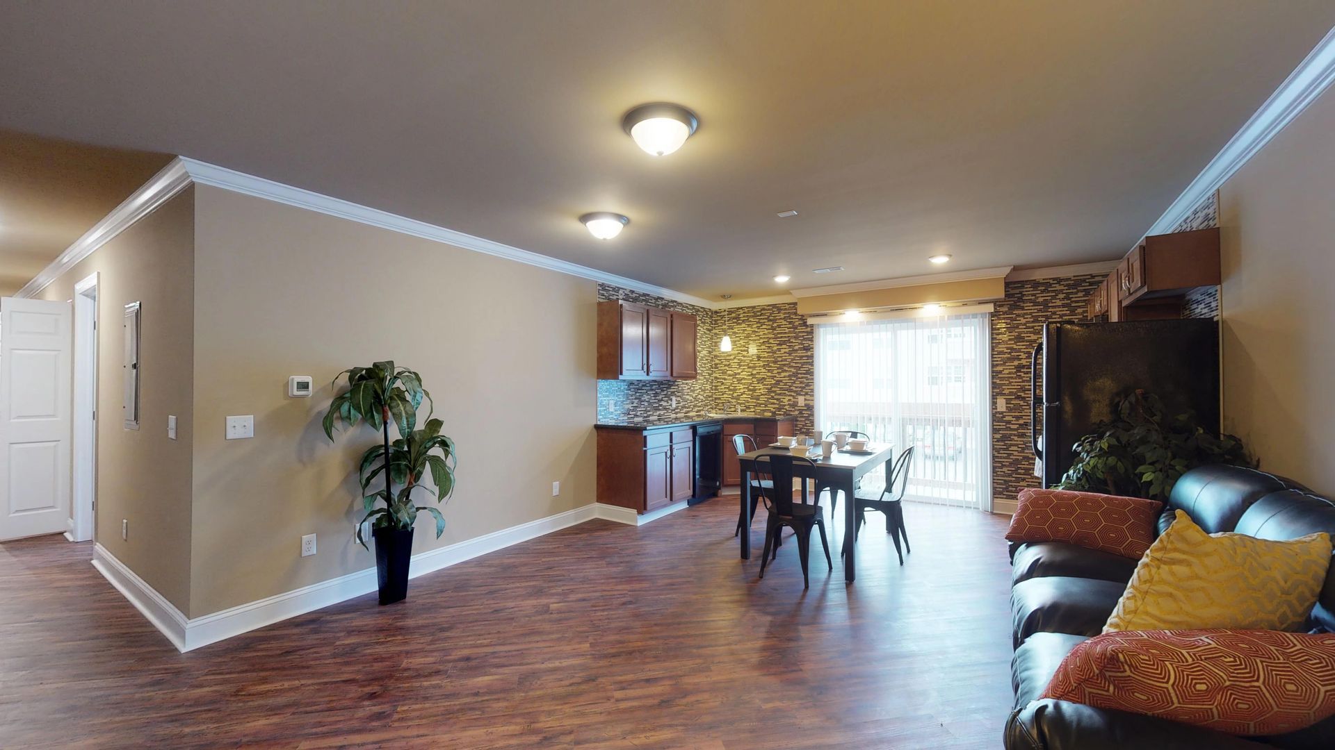 A living room with a couch , table and chairs.