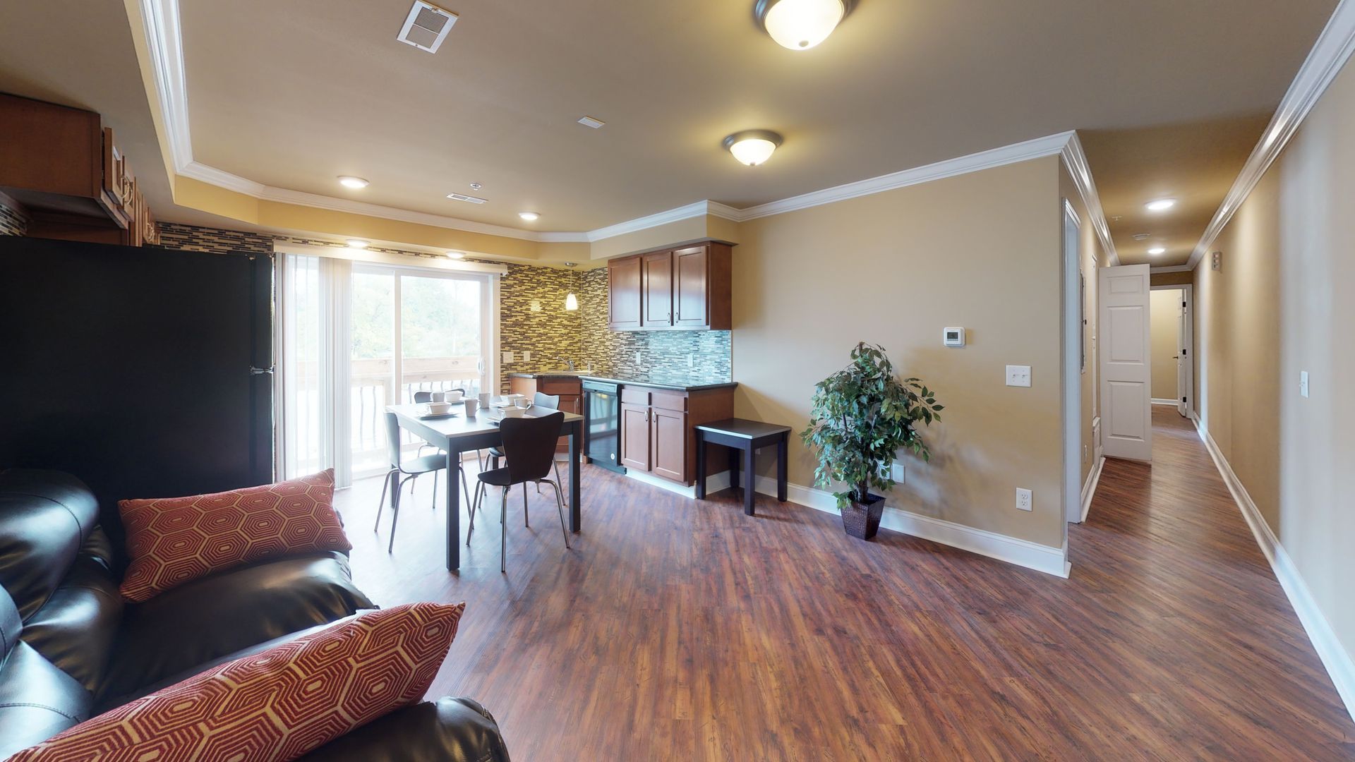 A living room with hardwood floors , a couch , a table and chairs.