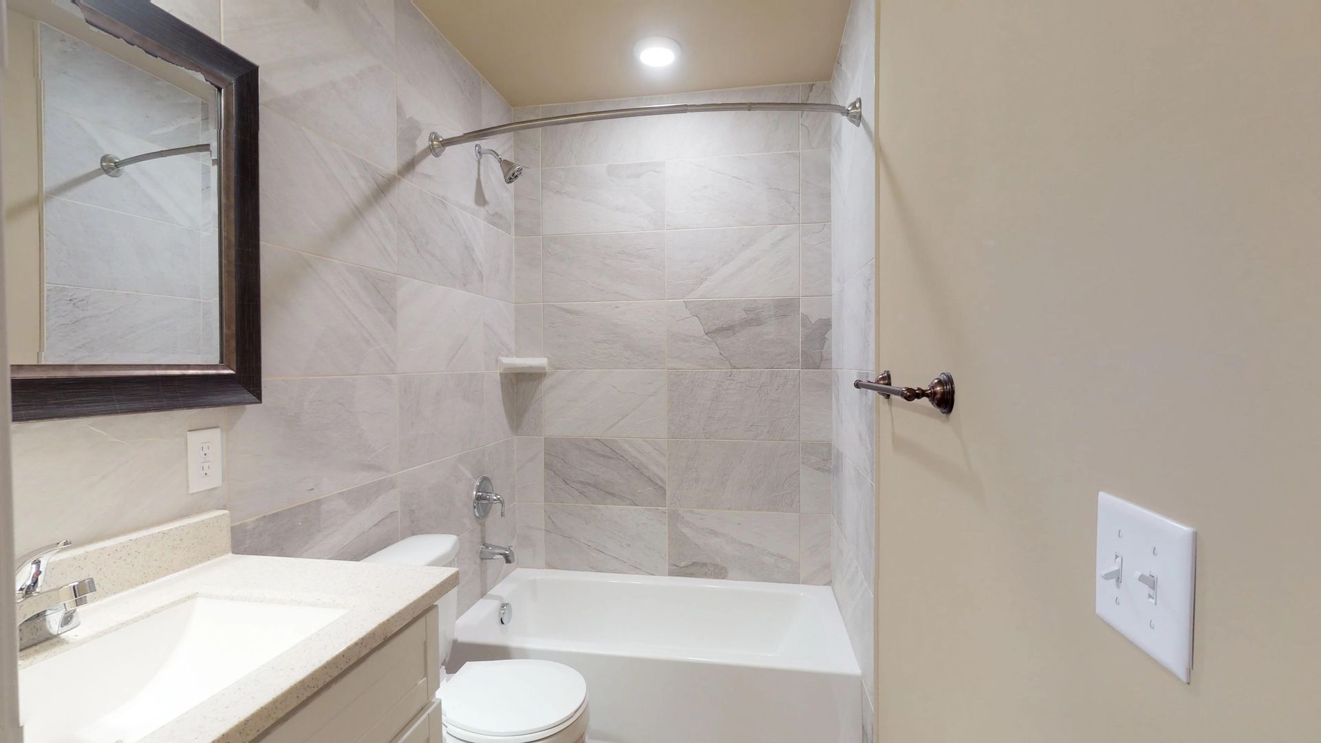 A bathroom with a sink , toilet , bathtub and mirror.