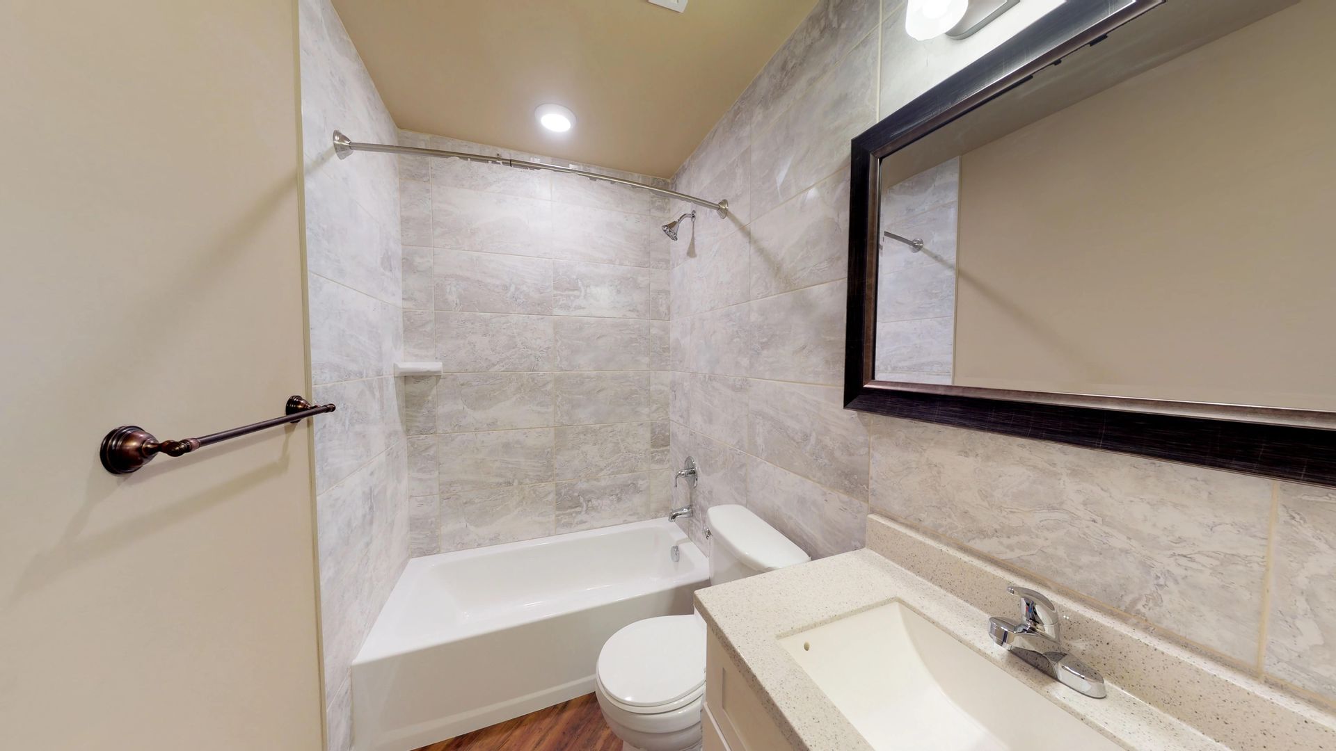 A bathroom with a toilet , sink , bathtub and mirror.