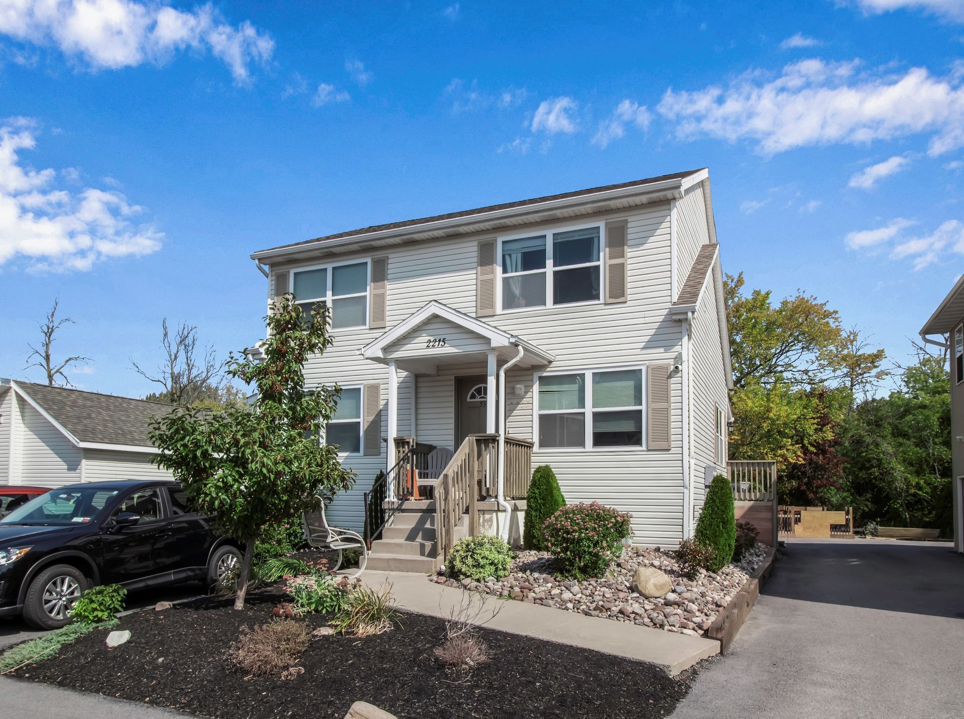 A white house with a black truck parked in front of it