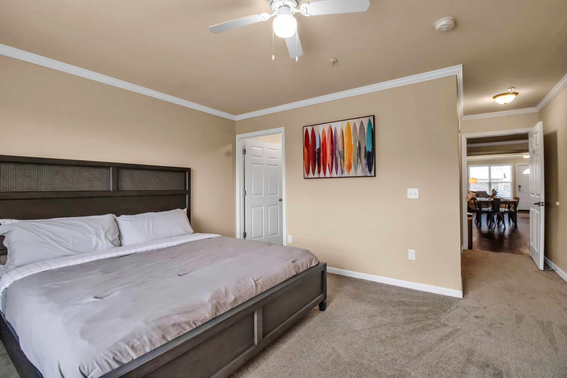 A bedroom with a king size bed and a ceiling fan.