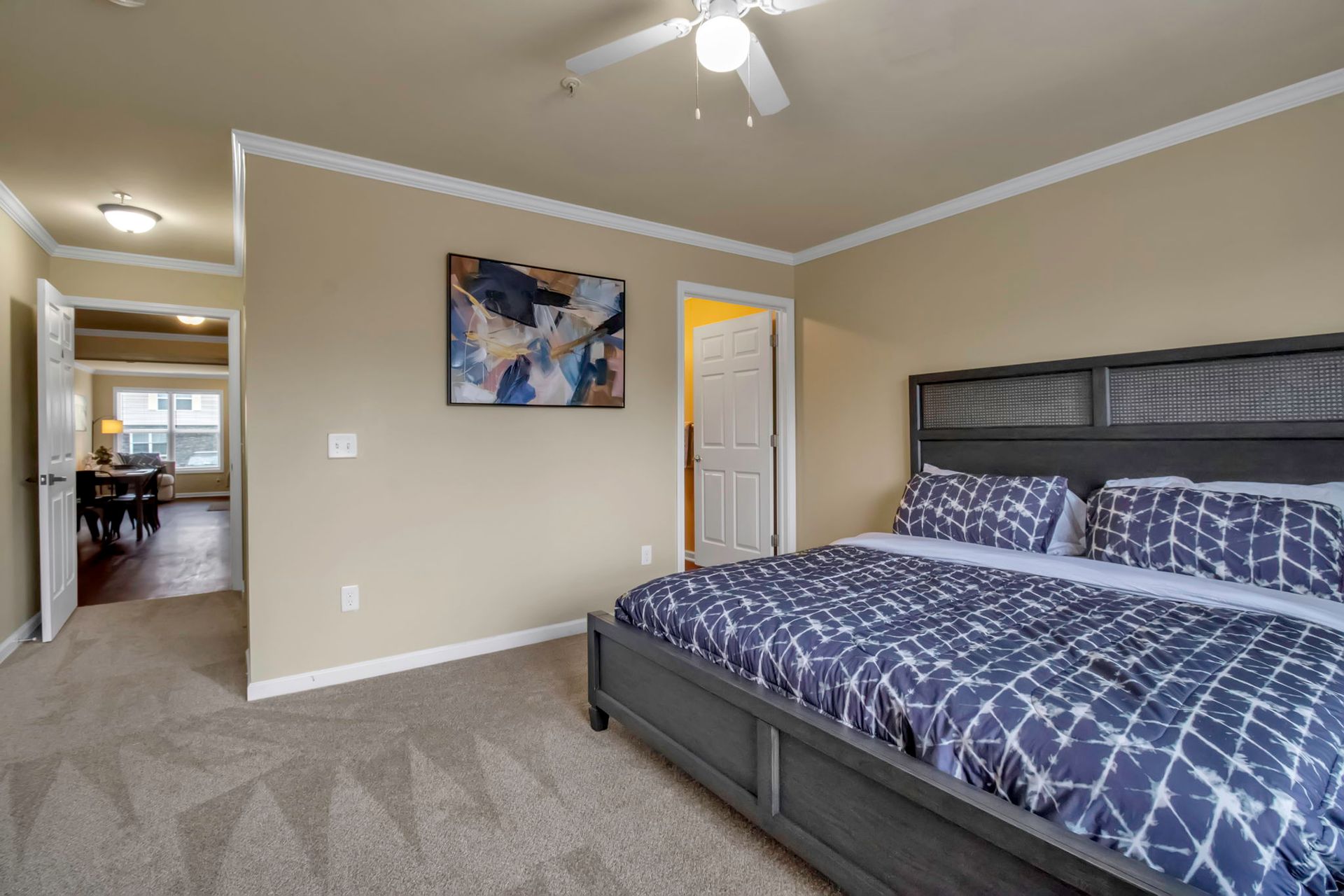 A bedroom with a king size bed and a ceiling fan.