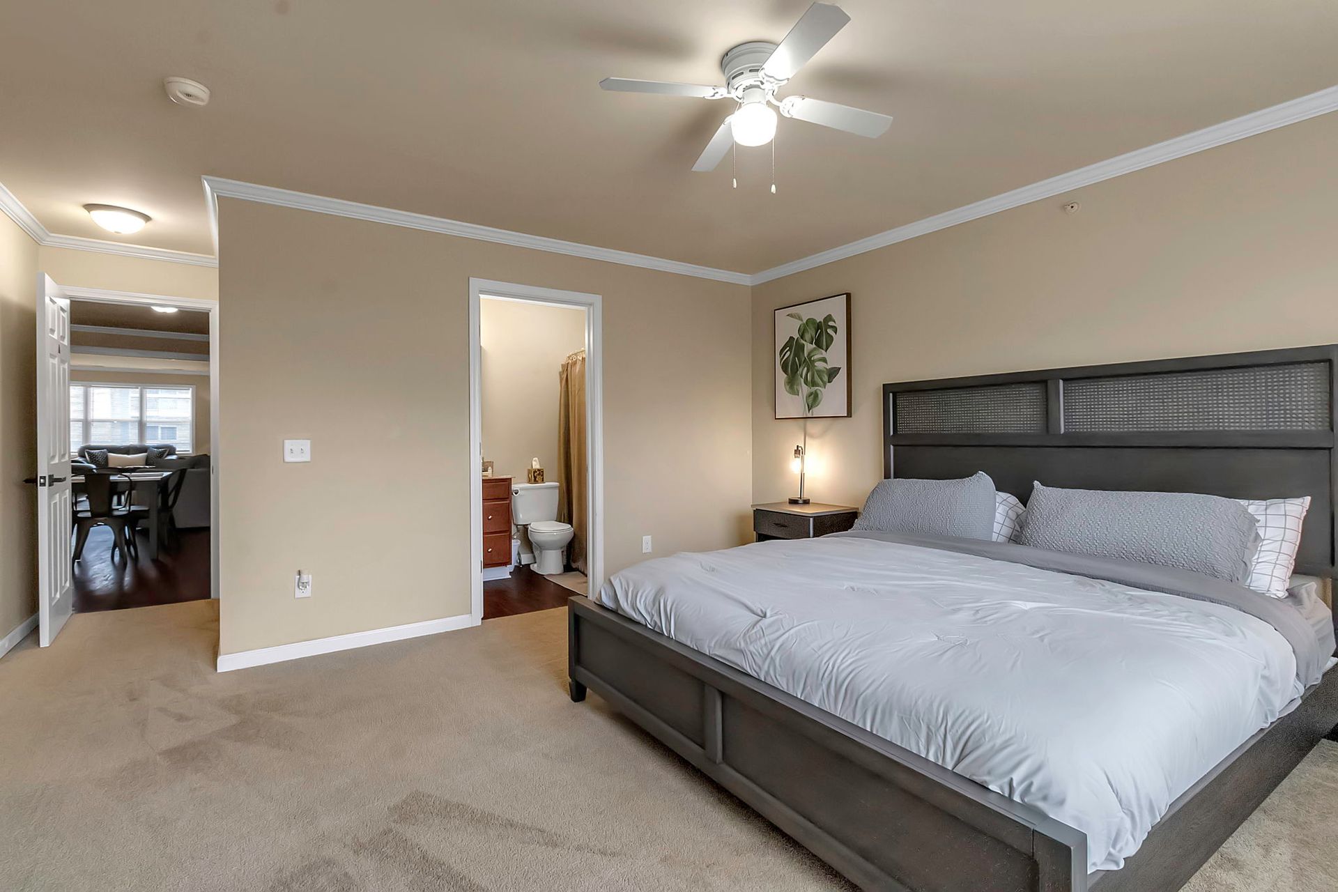 A bedroom with a king size bed and a ceiling fan.