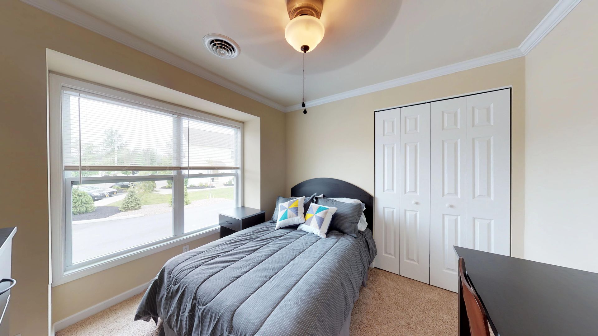 A bedroom with a bed , dresser , window and closet.