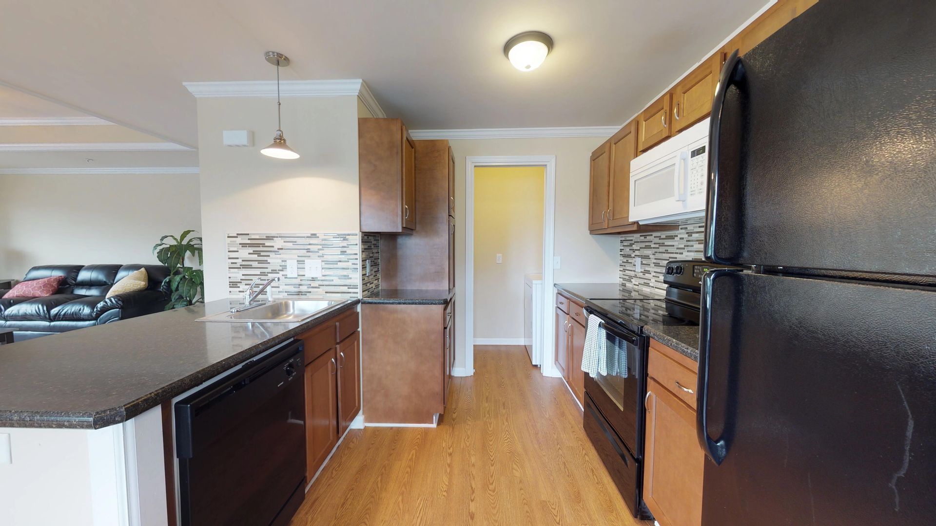 A kitchen with a black refrigerator , stove , dishwasher , and microwave.