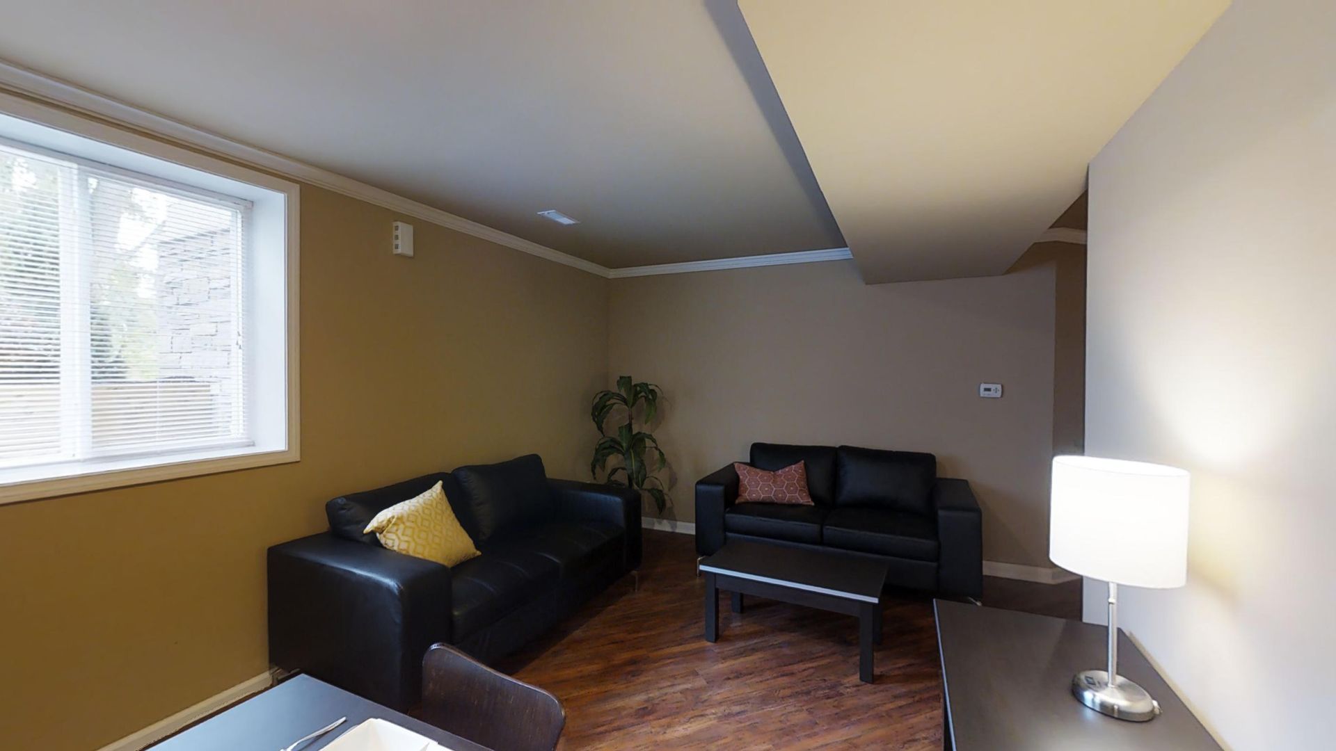 A living room with a couch a table and a lamp