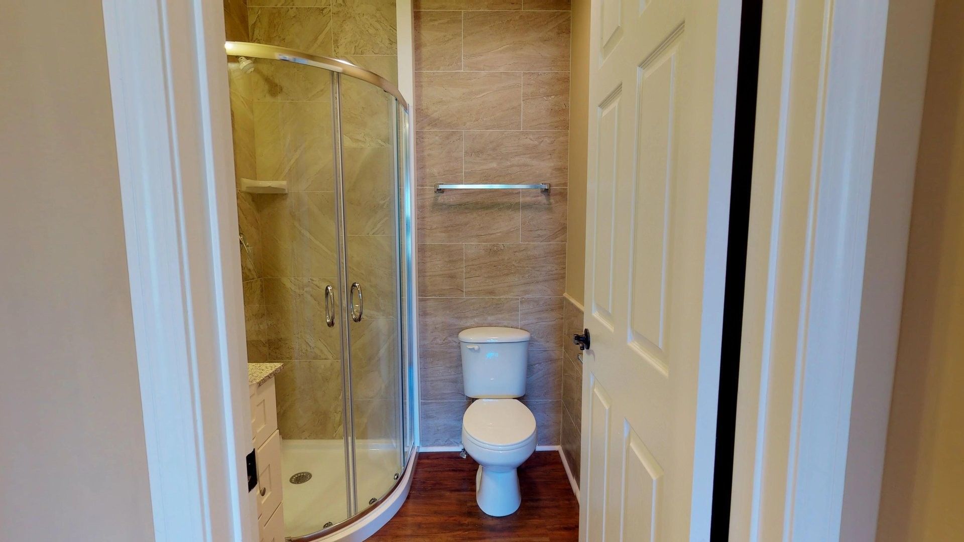 A bathroom with a toilet and a shower stall.
