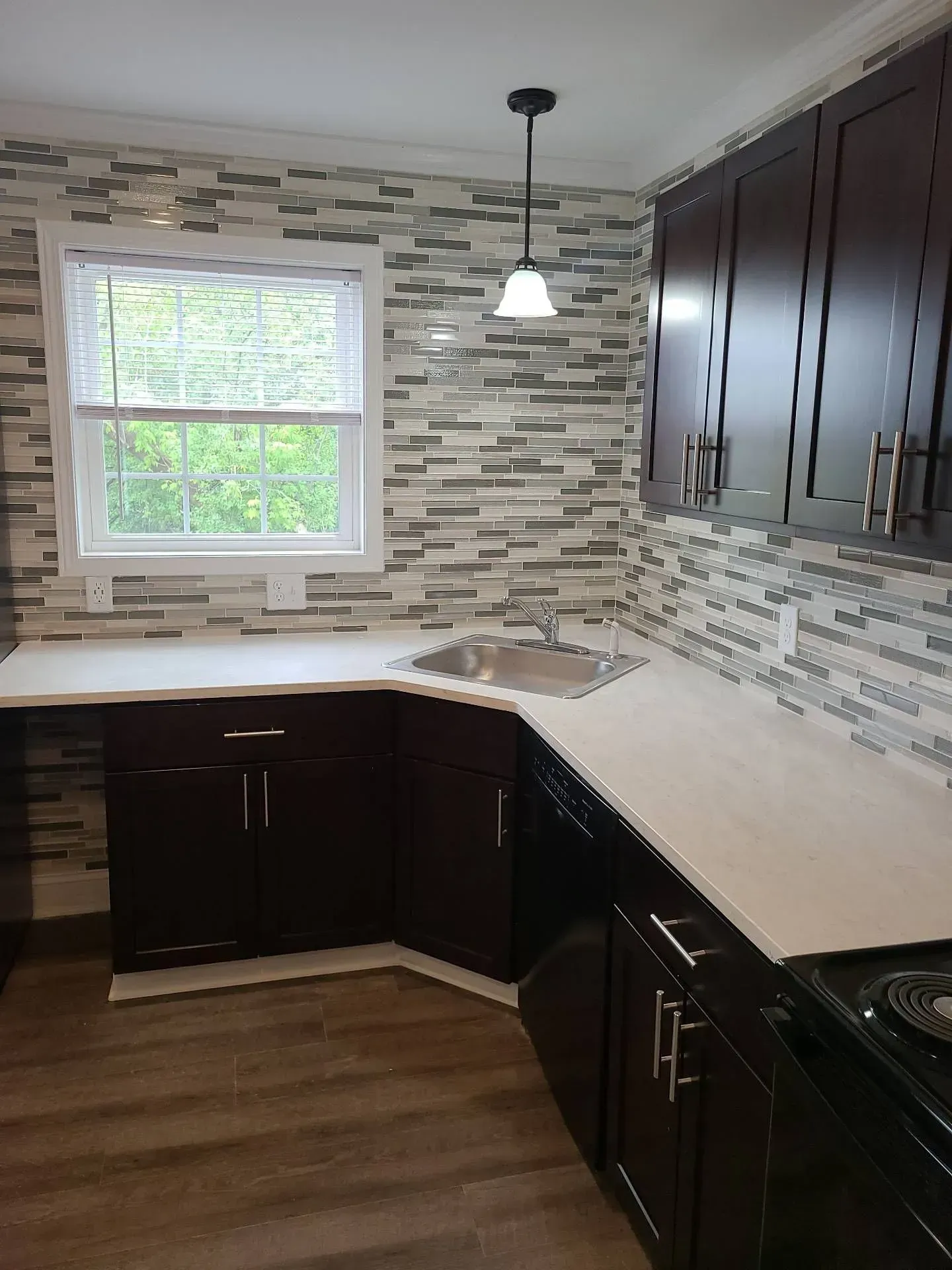 A kitchen with black cabinets and white counter tops