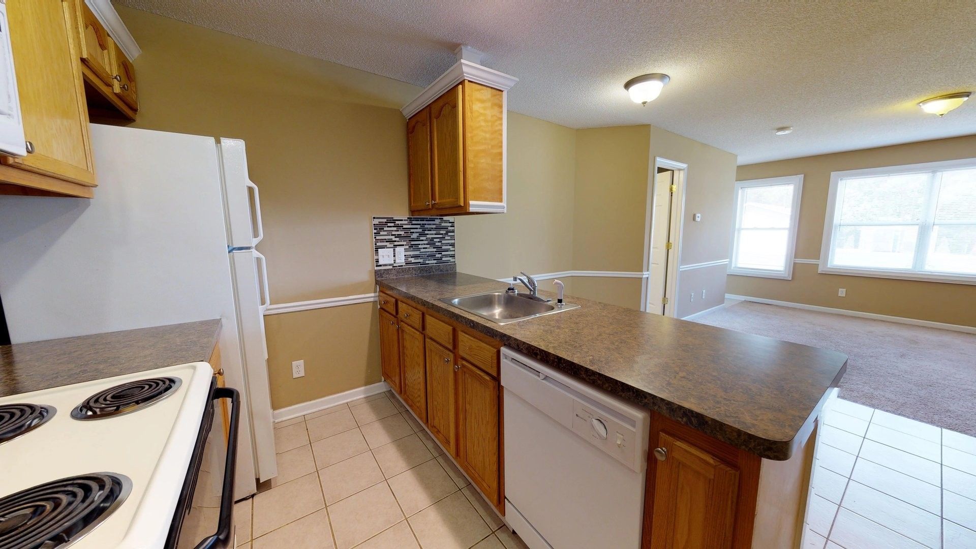 A kitchen with a stove , refrigerator , sink and dishwasher.