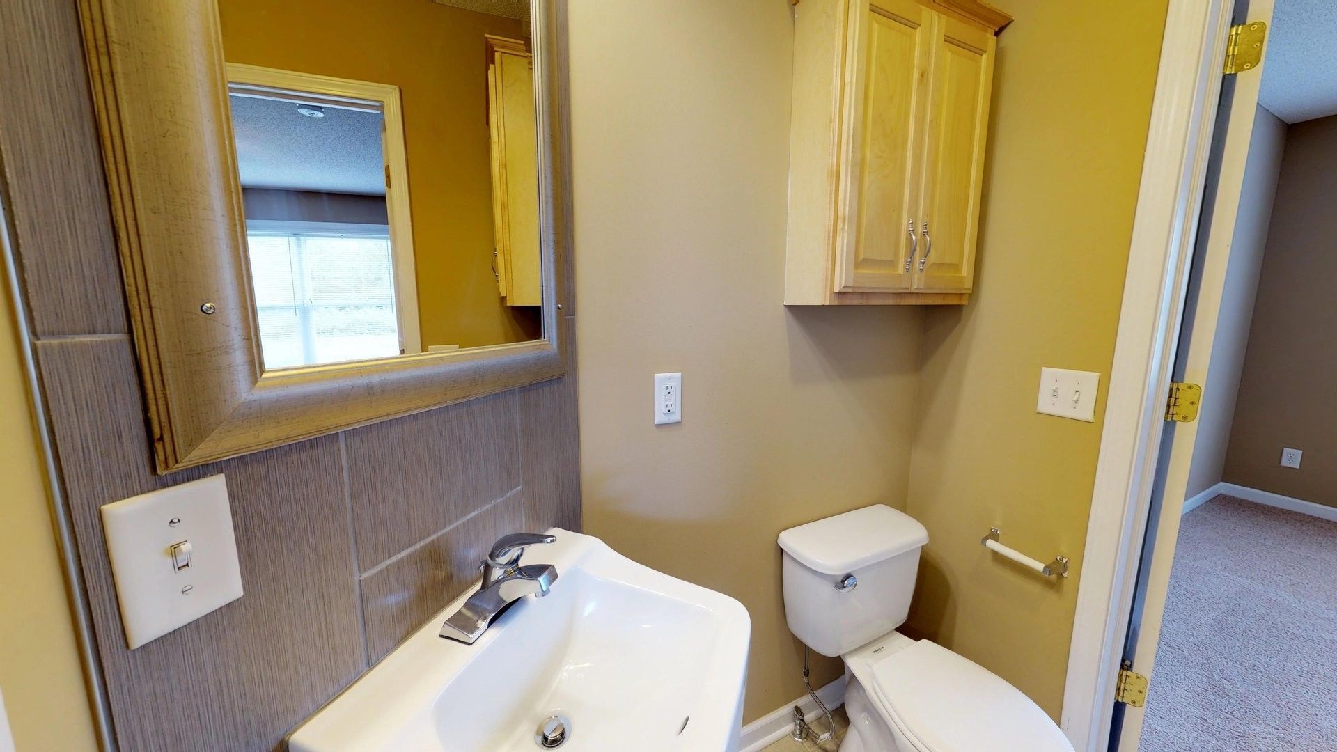 A bathroom with a sink , toilet and mirror.