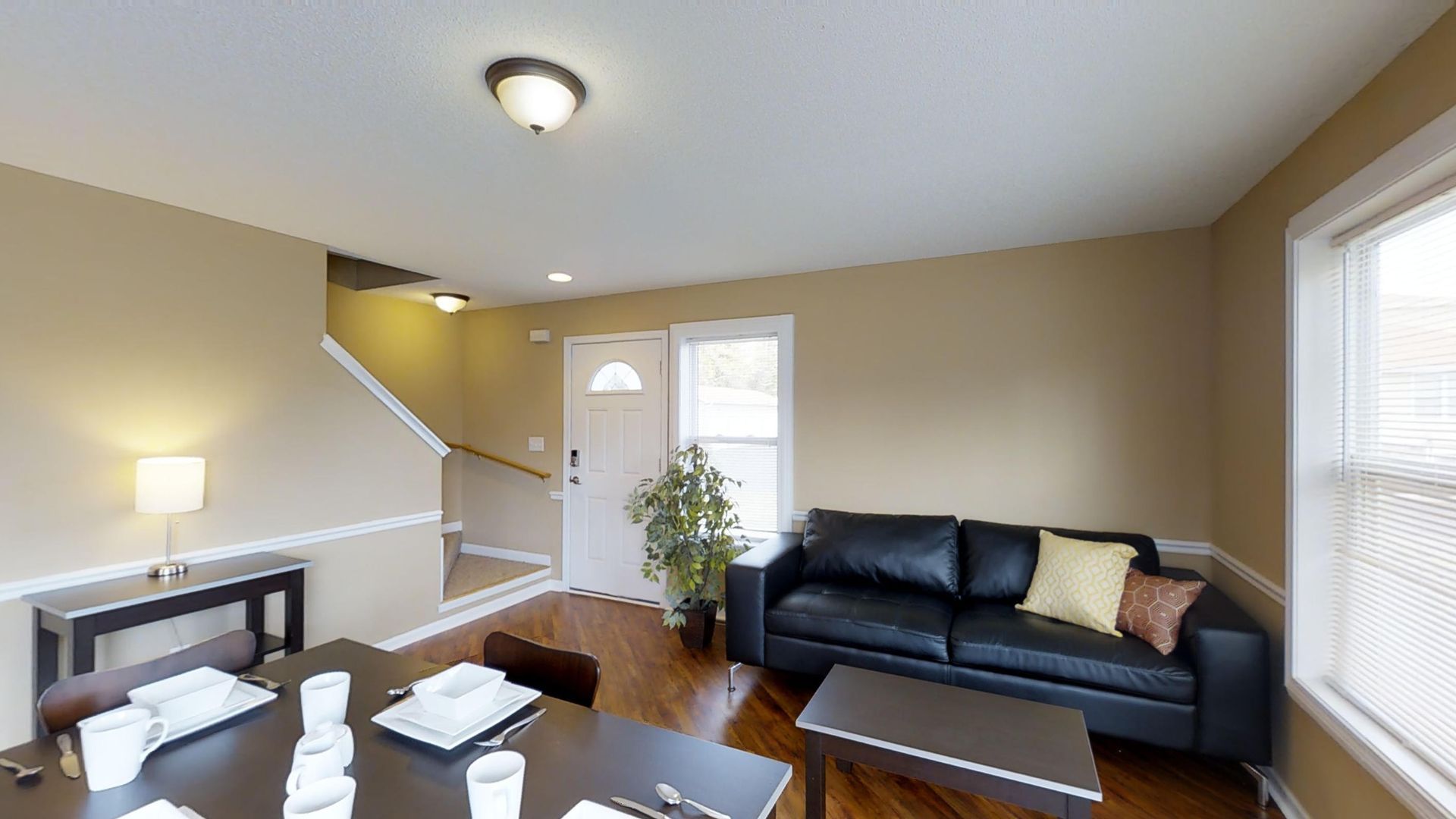 A living room with a couch , table and chairs