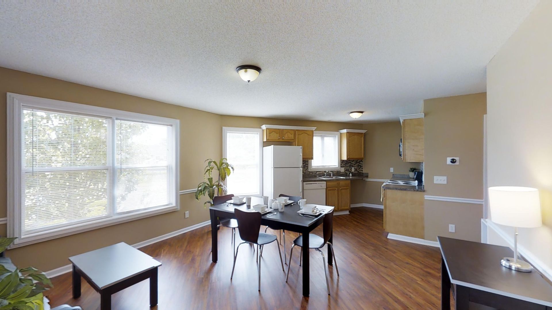 A living room with a table and chairs and a kitchen