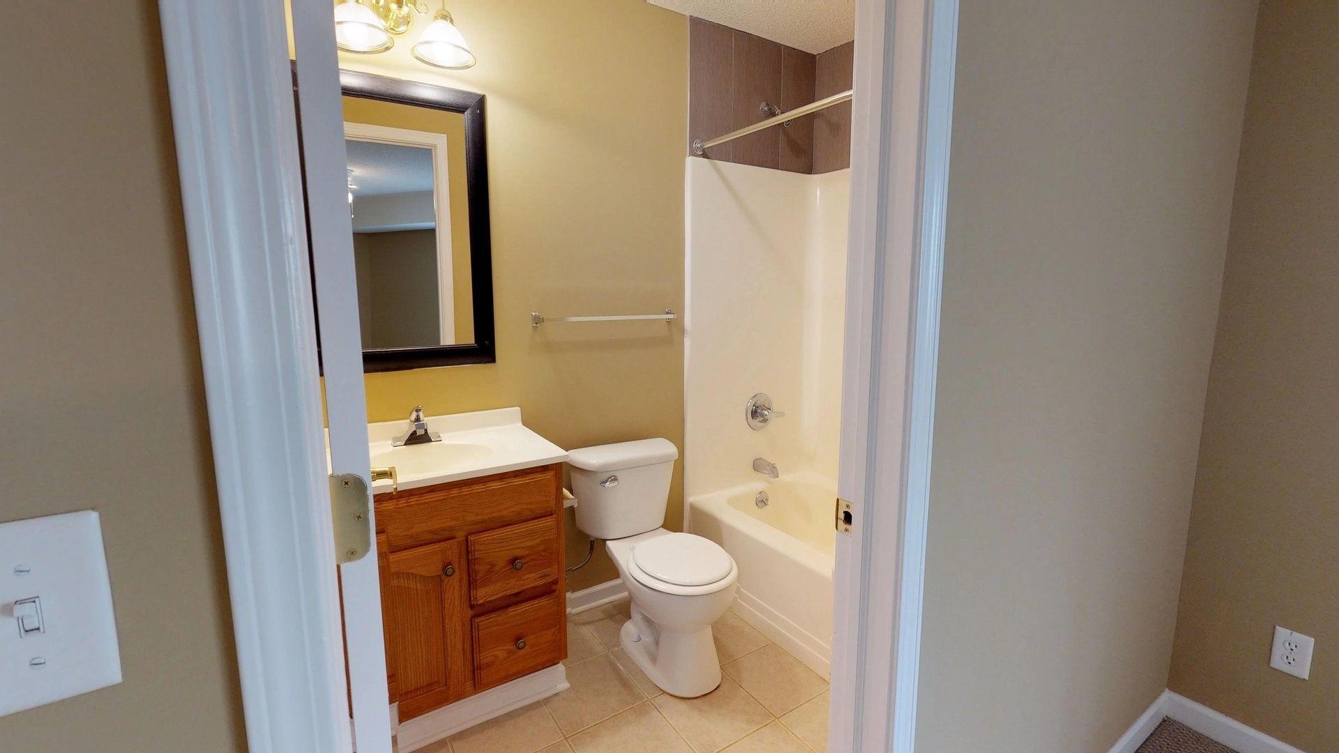 A bathroom with a toilet , sink and bathtub.