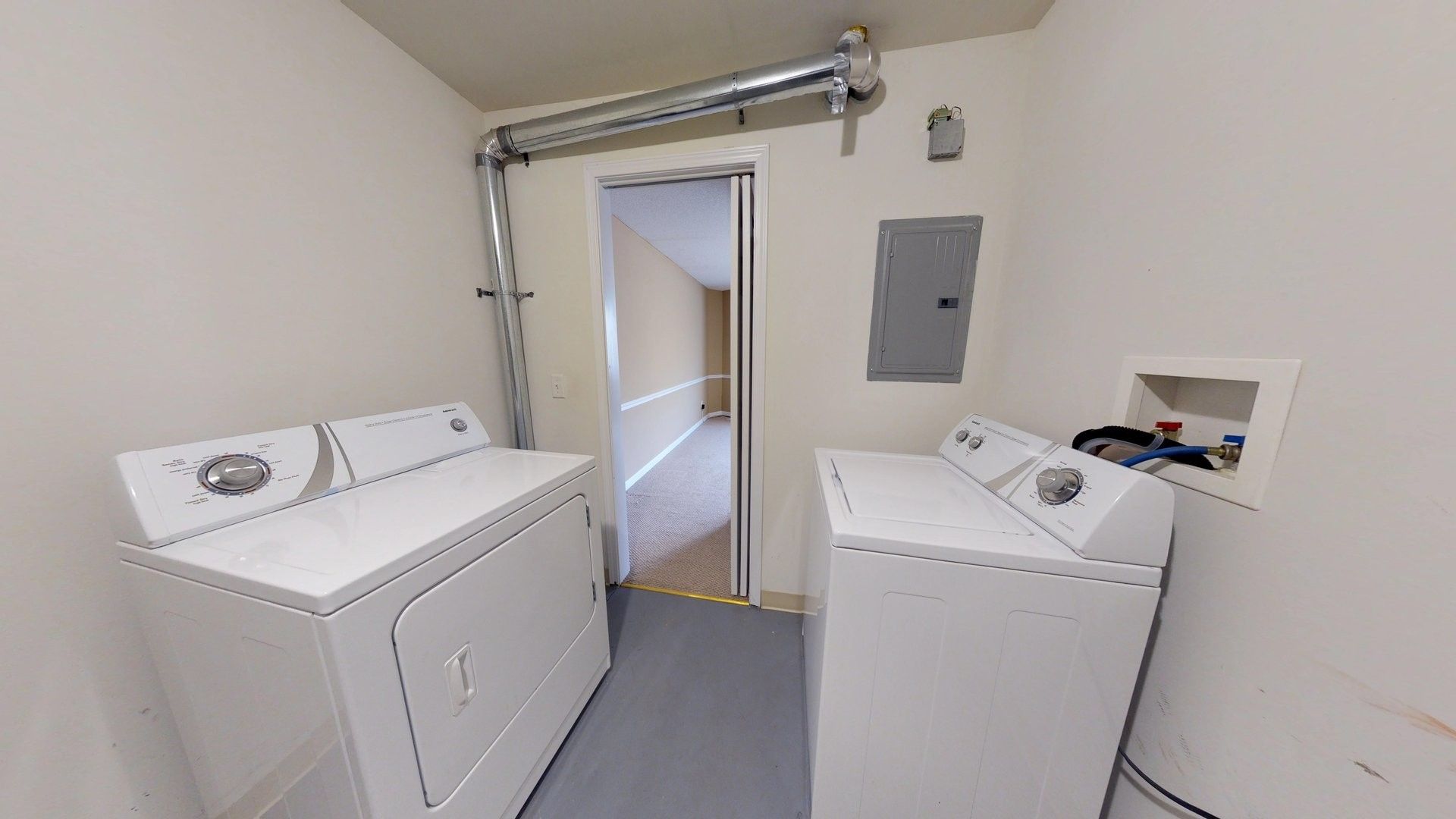 A laundry room with two white washers and dryers.