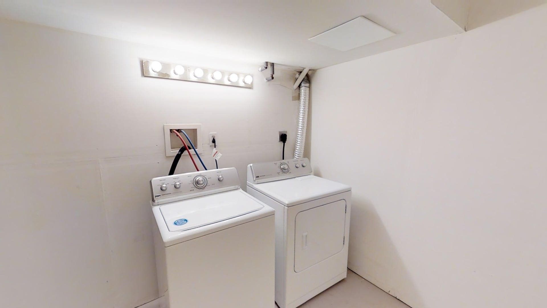 A laundry room with two white washers and dryers.