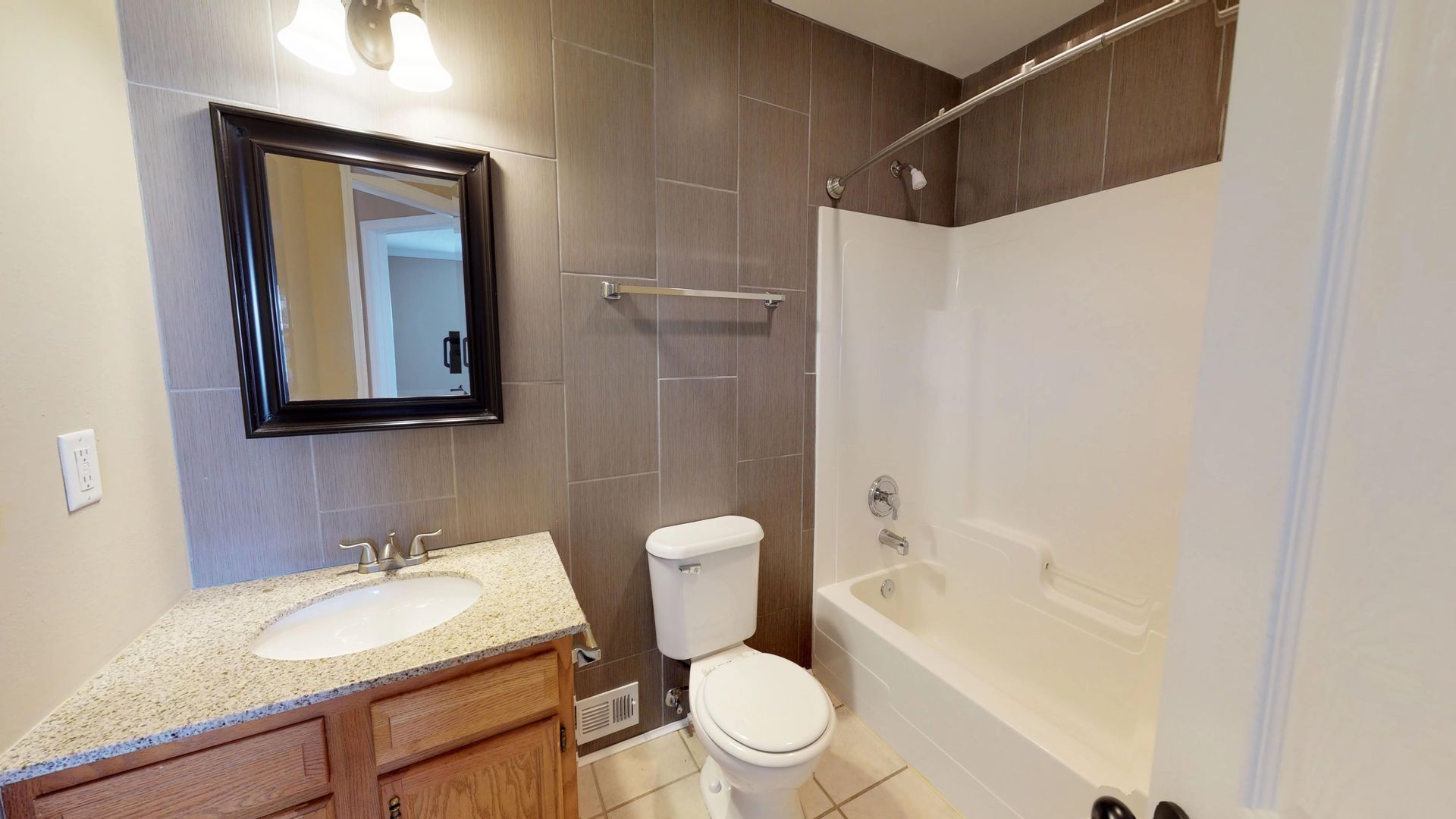 A bathroom with a toilet , sink , mirror and bathtub.