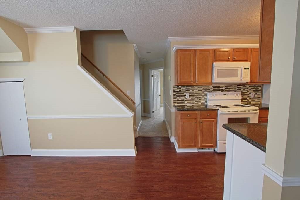 An empty house with a kitchen and stairs