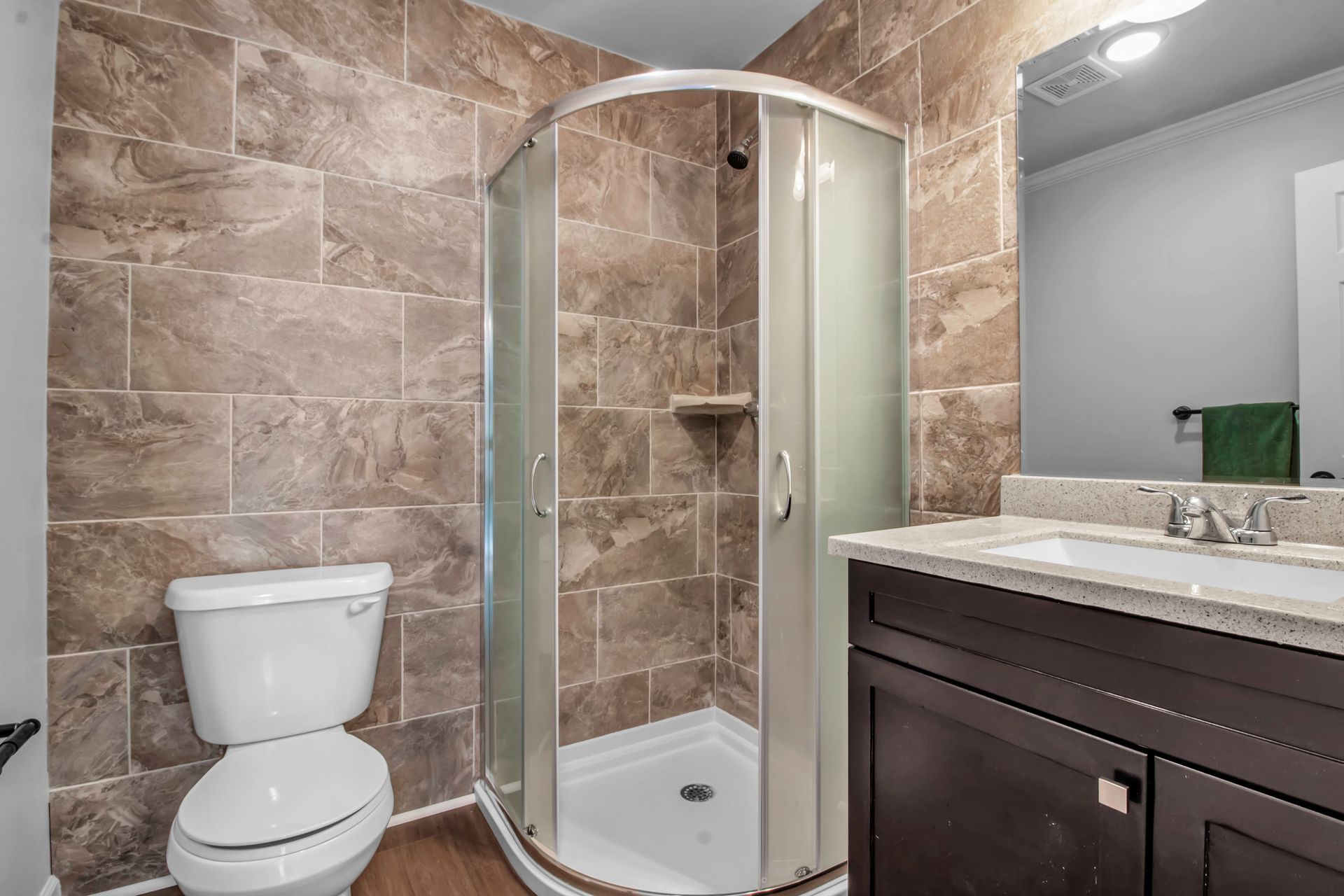 A bathroom with a toilet , sink and shower stall.