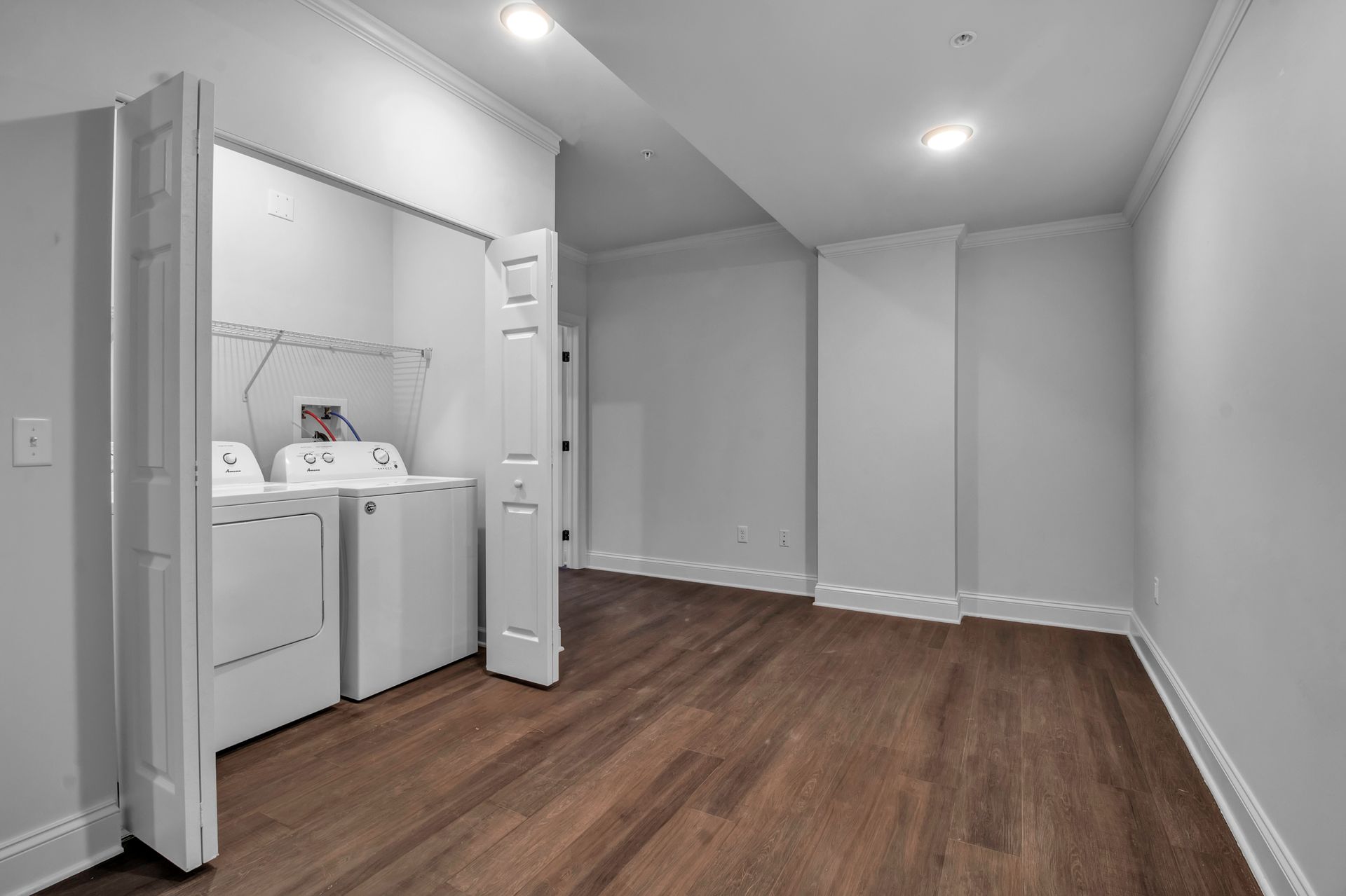 An empty laundry room with a washer and dryer in it.