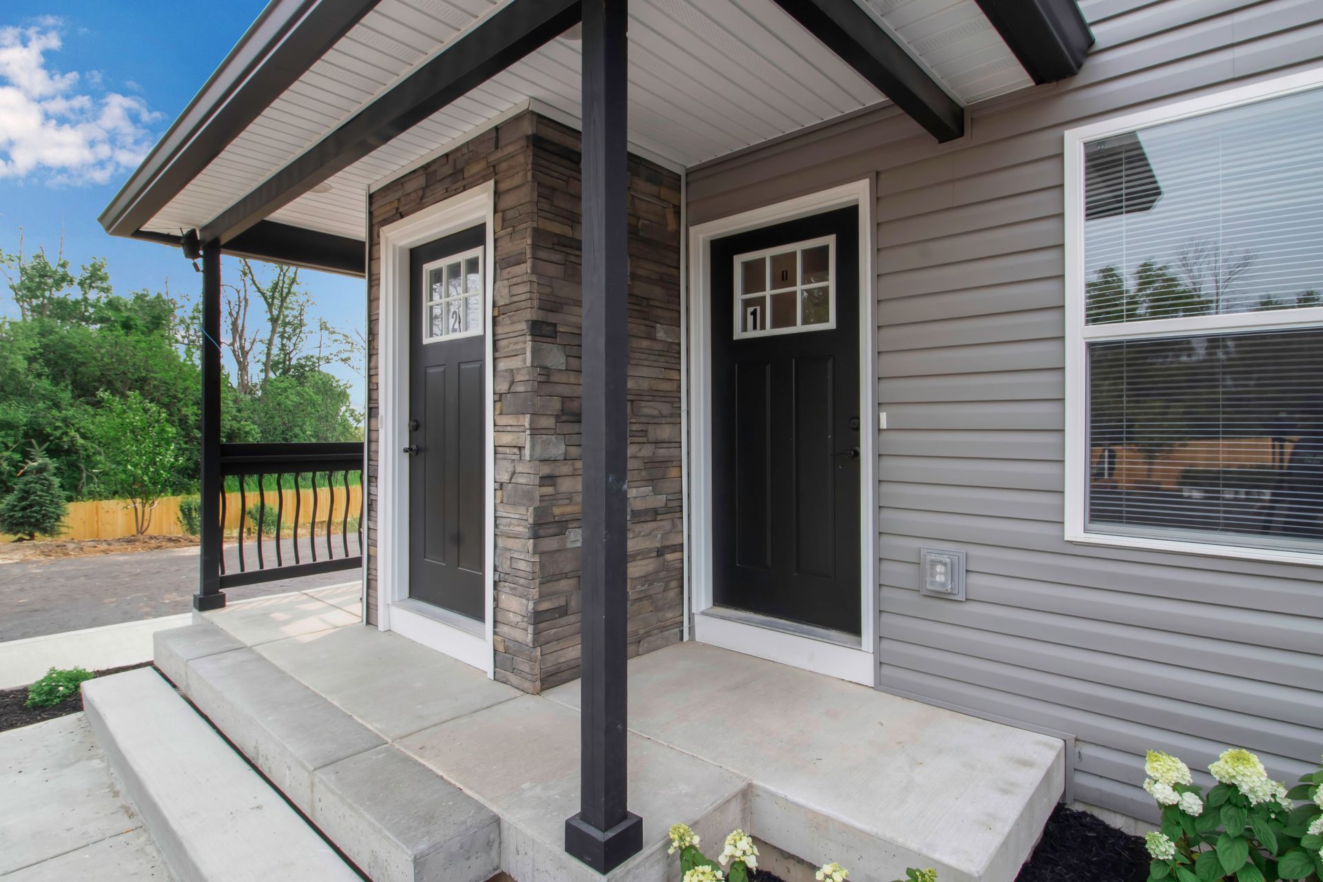 A house with a porch and two black doors.