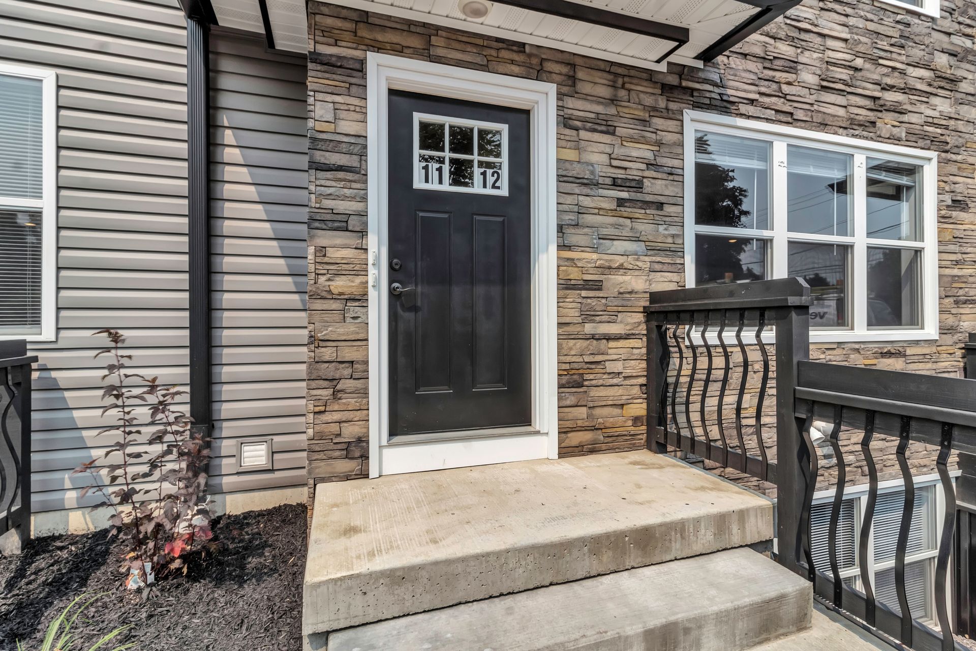 The front door of a house with stairs leading up to it